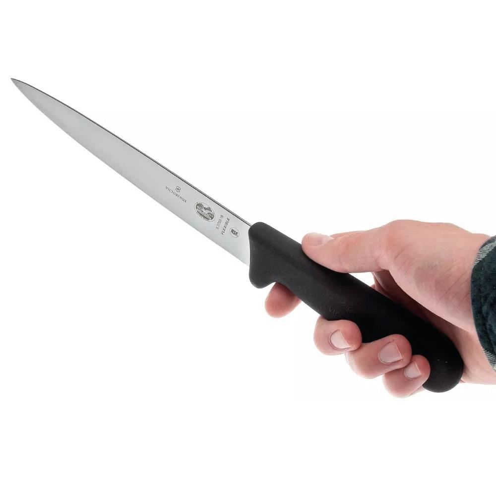 Bir el, siyah saplı, gümüş bıçaklı Victorinox esnek bıçağı tutuyor.