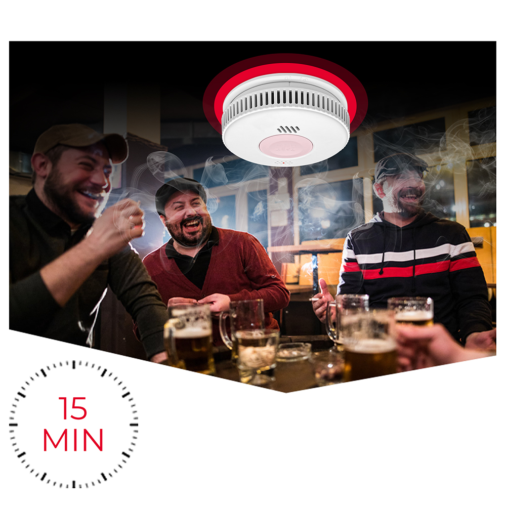 Czujnik dymu nad śmiejącymi się mężczyznami z piwem, palącymi na zewnątrz.