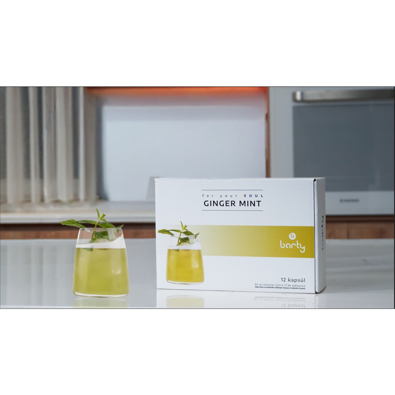 Zencefil nane içeceği bardağı, üzerinde GINGER MINT yazan kutunun yanında.