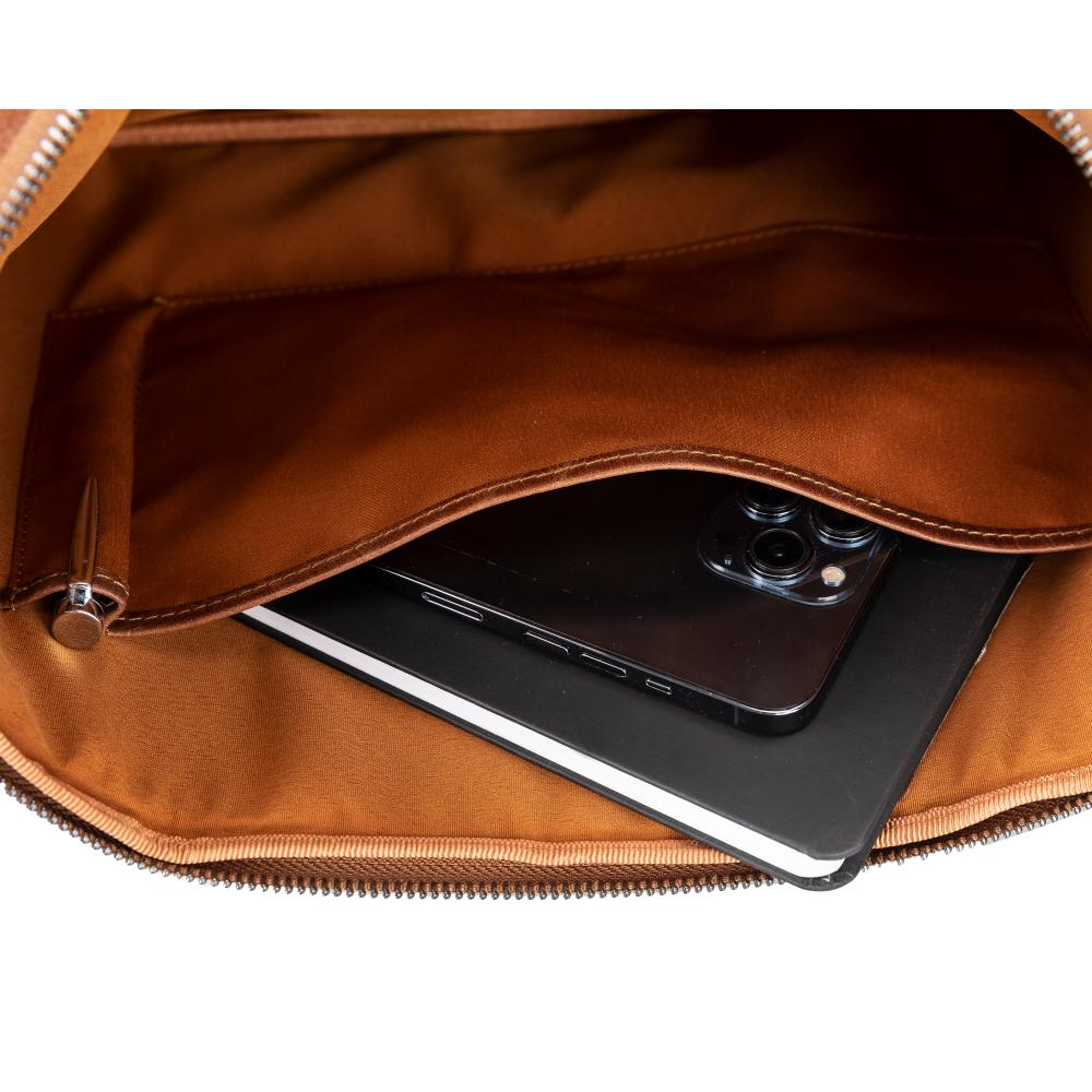 Kahverengi çanta içi: telefon, defter ve kalem.