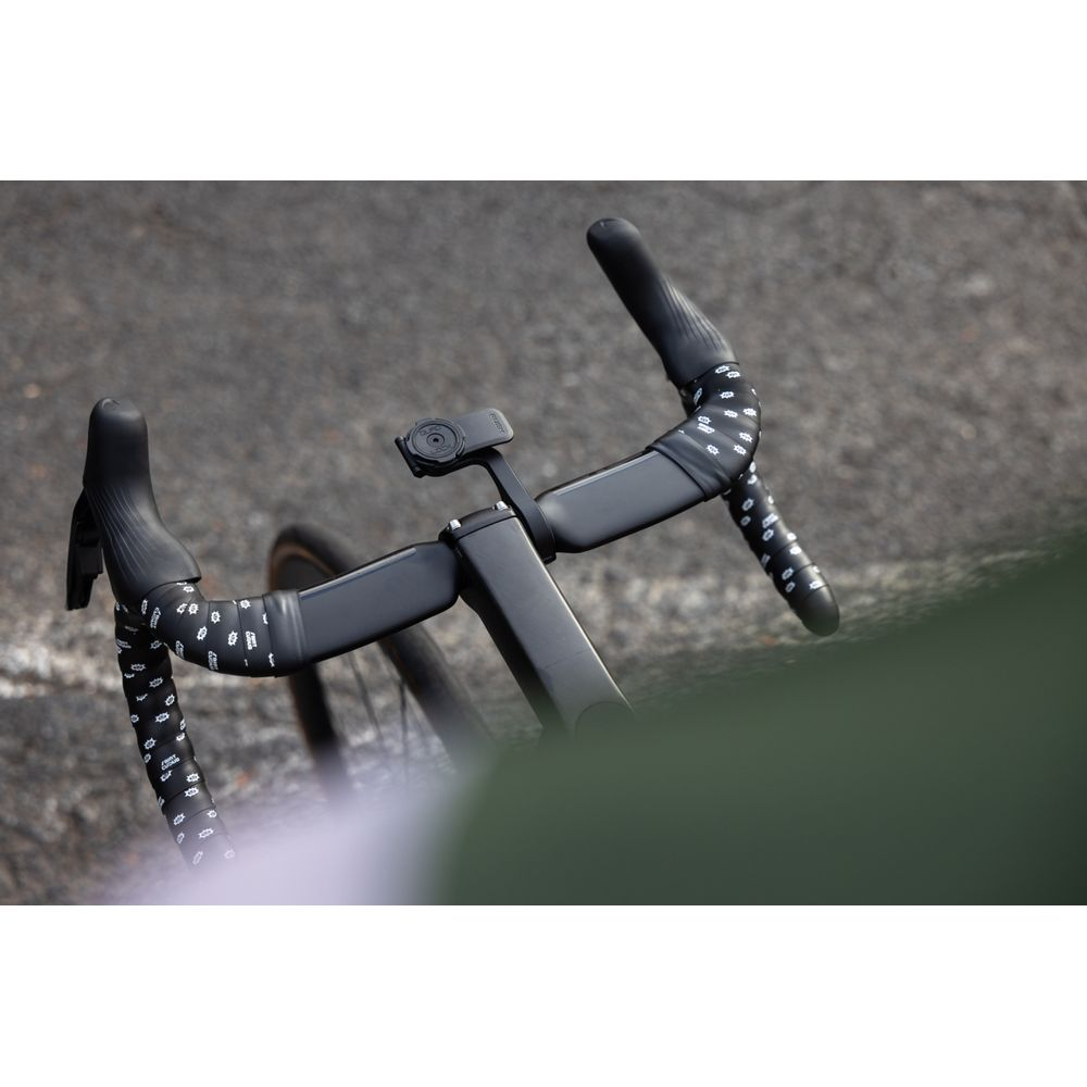 Schwarzer Fahrradlenker mit weißem Muster und einem kleinen Gerät.