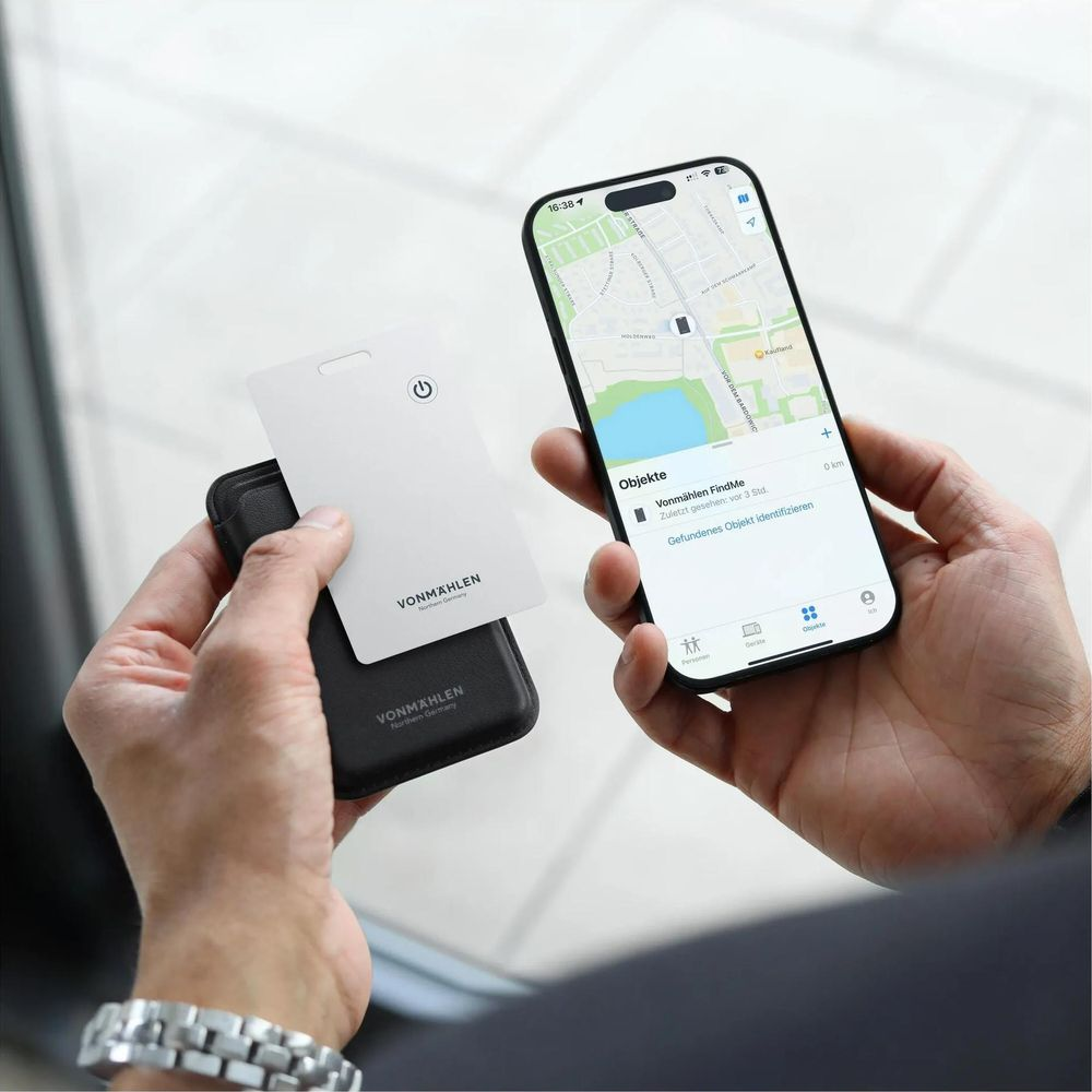 Person hält Smartphone mit Karte und Schlüsselanhänger. Karte zeigt Logo.