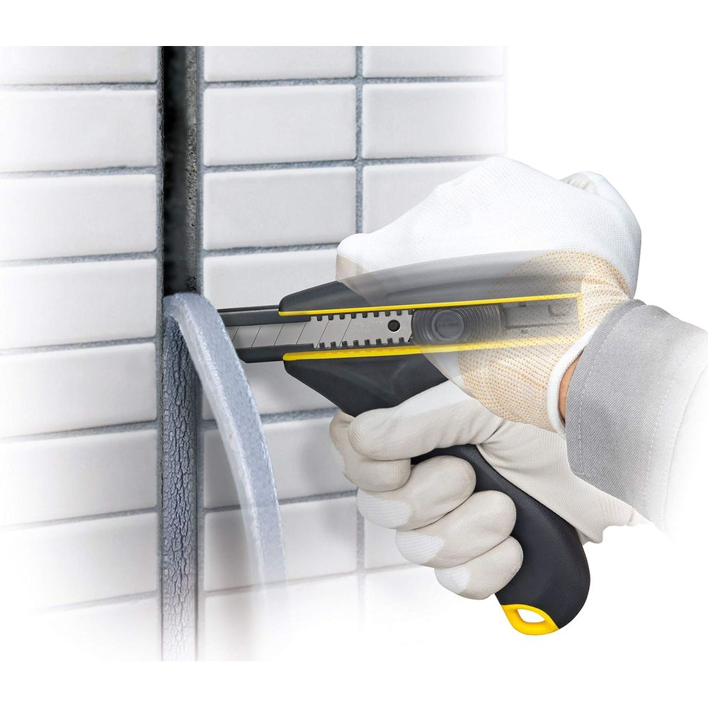 Hände mit Handschuhen schneiden mit einem Cuttermesser grauen Kitt von weißen Fliesen.