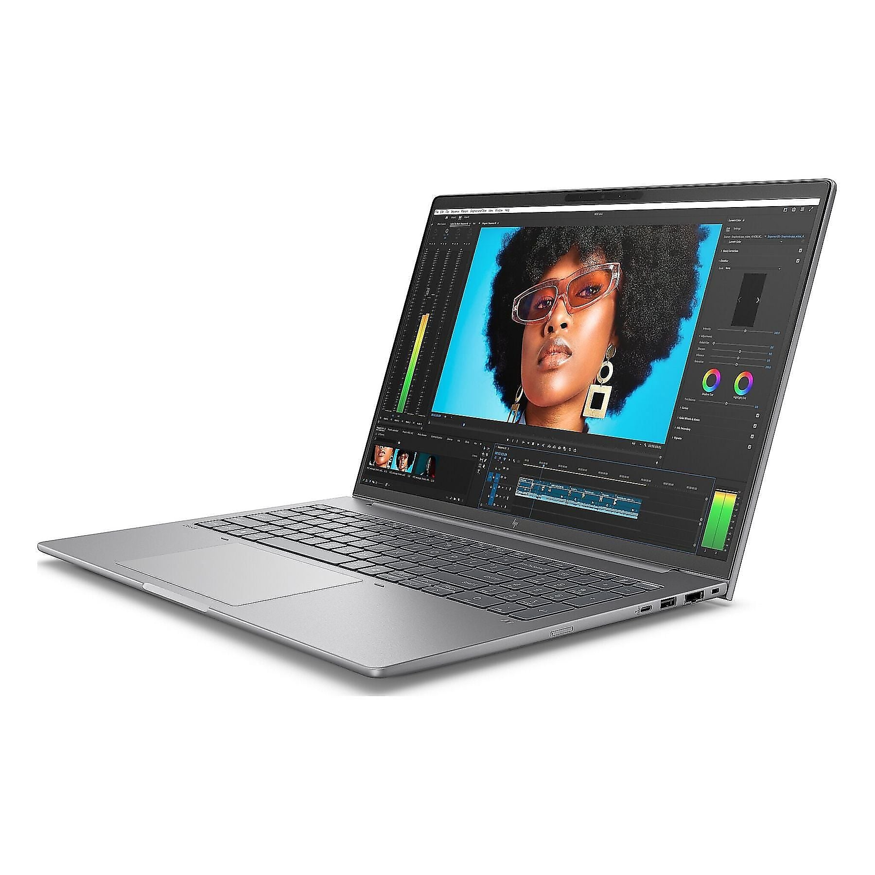 Un laptop argentato aperto mostra software di video editing con il ritratto di una donna.