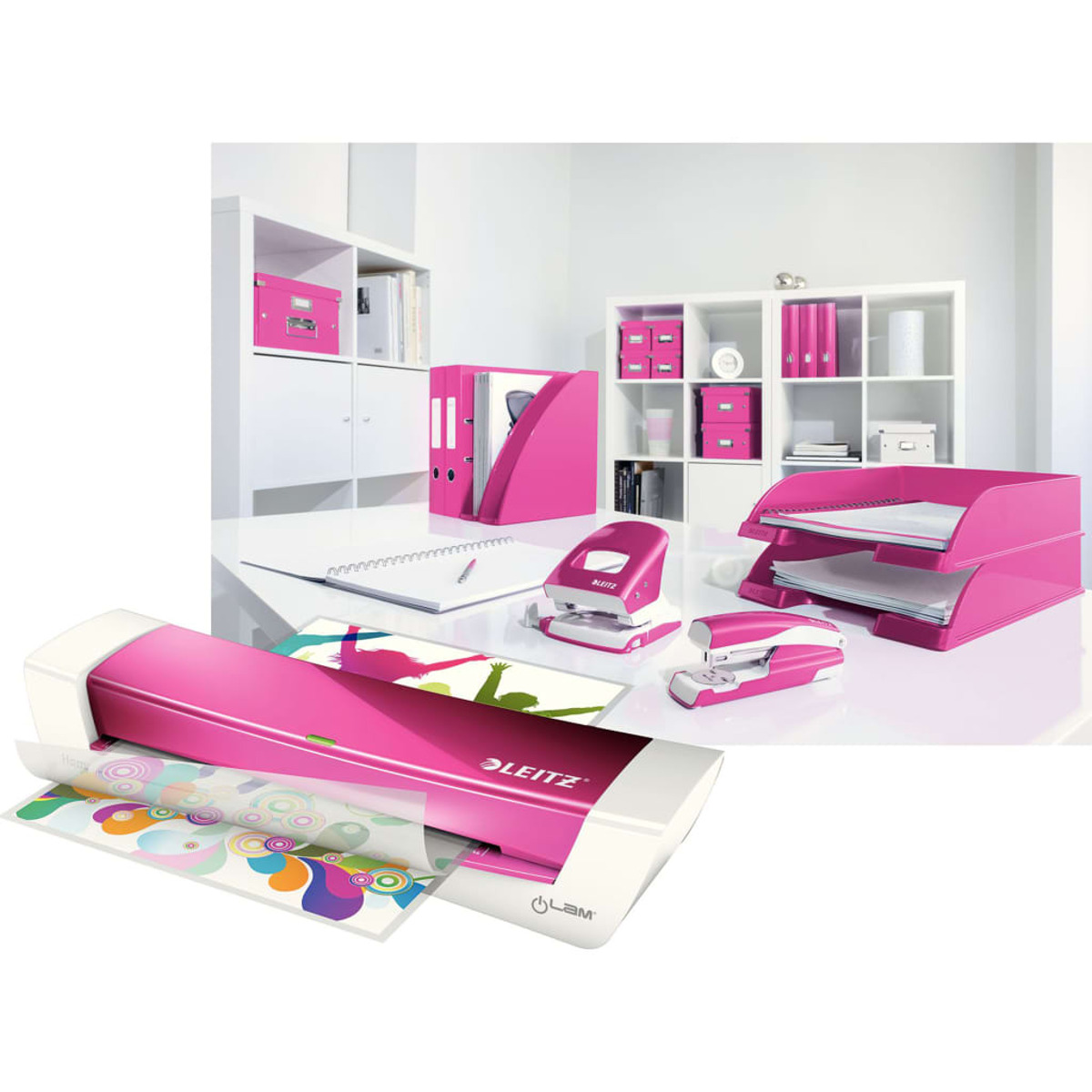 Rosa Büromaterialien: Laminator, Heftgeräte, Papierablage, Ordner, auf weißem Schreibtisch.