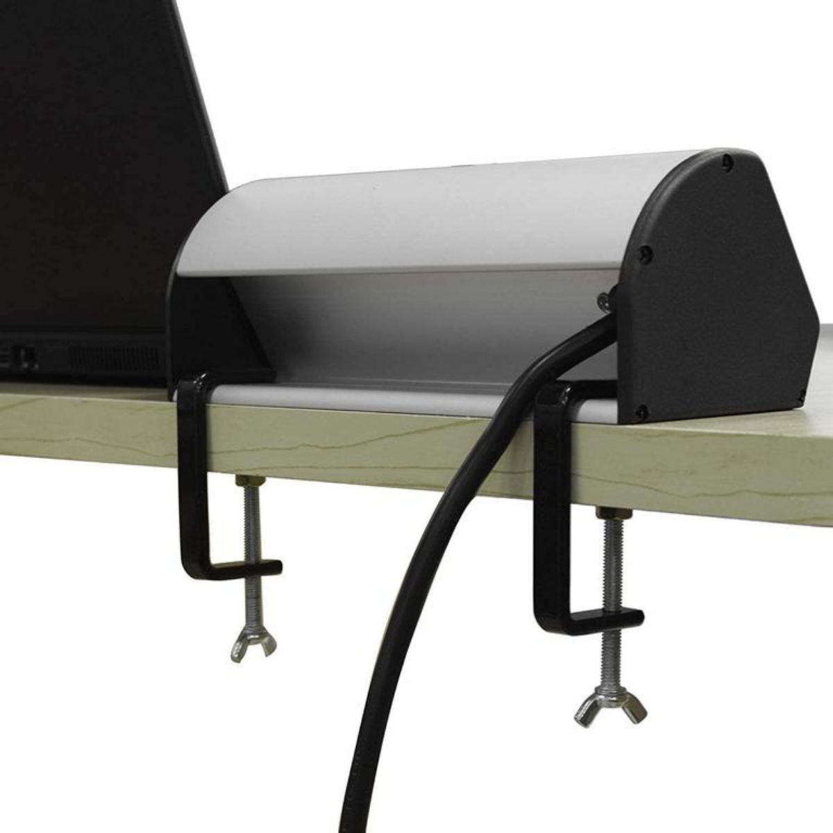 Ein silbernes und schwarzes Gerät mit Kabeln, das an einem Schreibtisch befestigt ist.