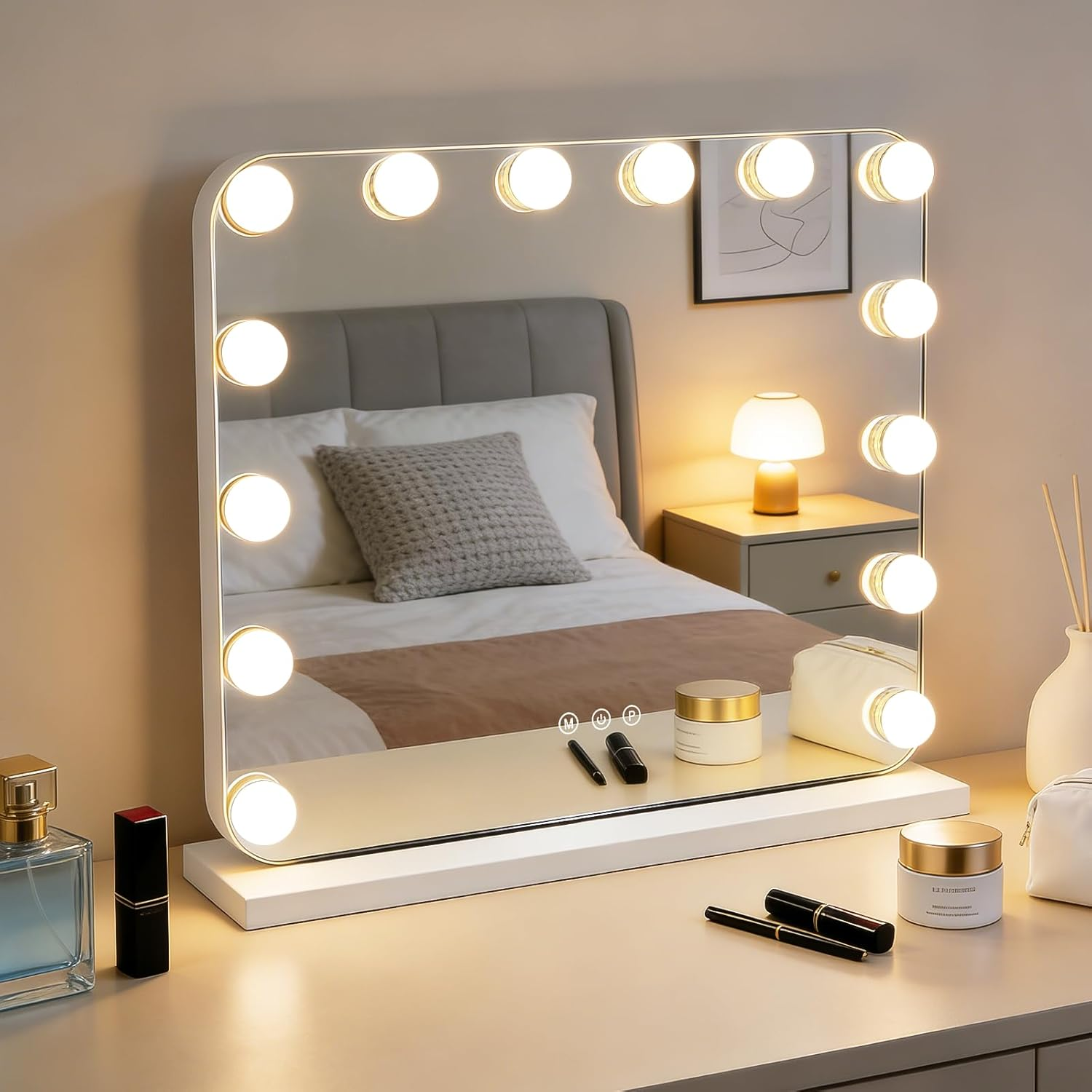 Uno specchio per il trucco illuminato con trucchi e un letto riflesso.
