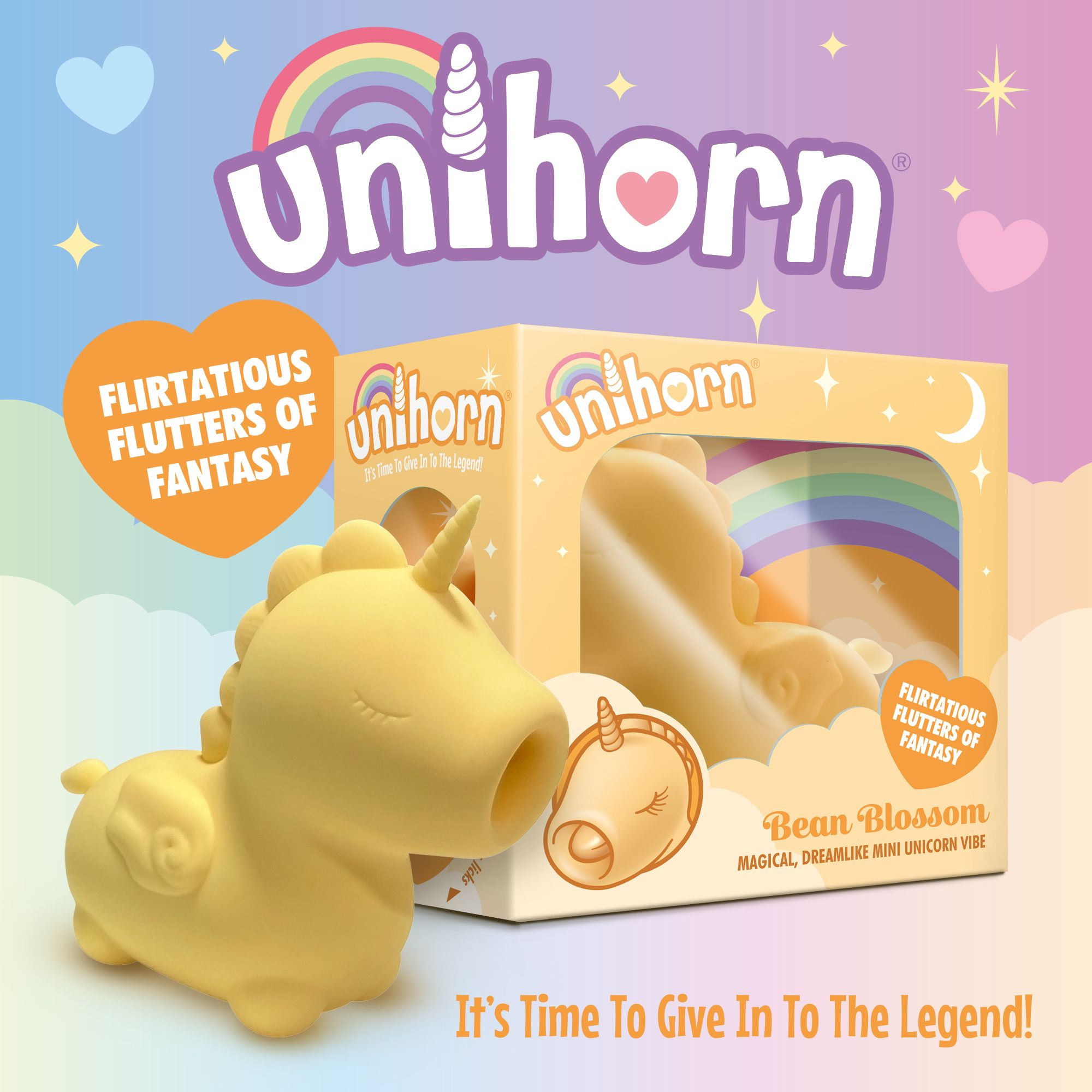 Ein gelbes Einhorn-Spielzeug steht neben seiner Verpackung mit Regenbogen und Wolken.