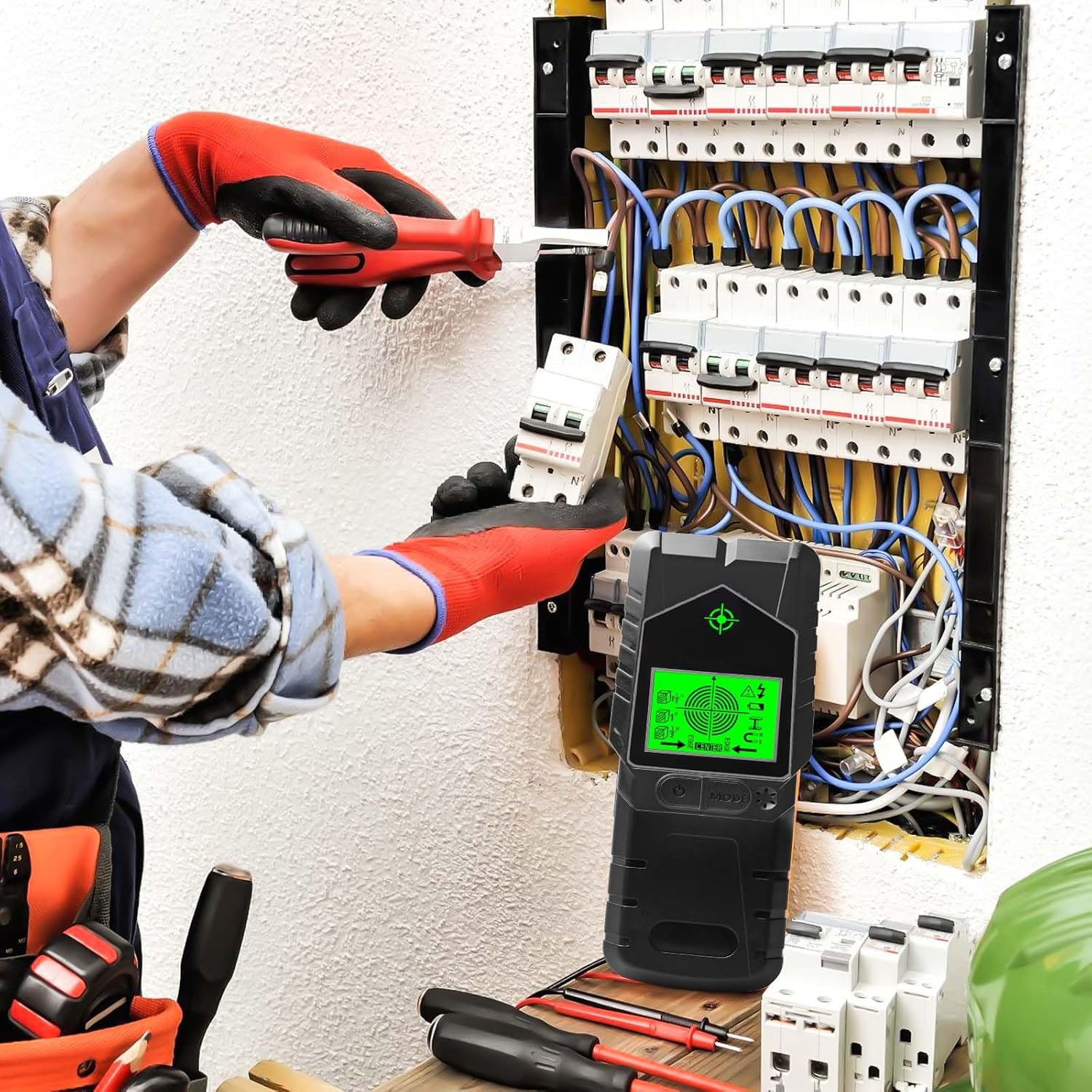 Elektriker mit roten Handschuhen benutzt Schraubendreher & Detektor am Sicherungskasten mit Drähten.