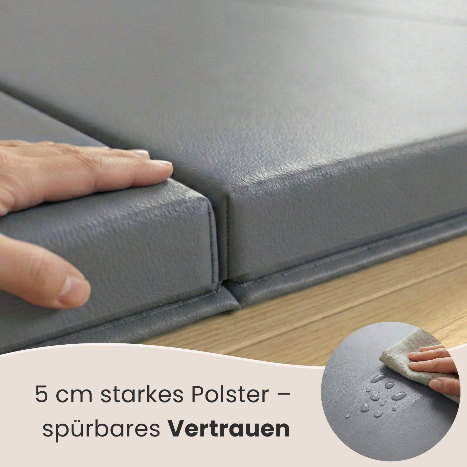 Eine Hand berührt eine graue, gepolsterte Oberfläche. Wassertropfen auf grauem Material.