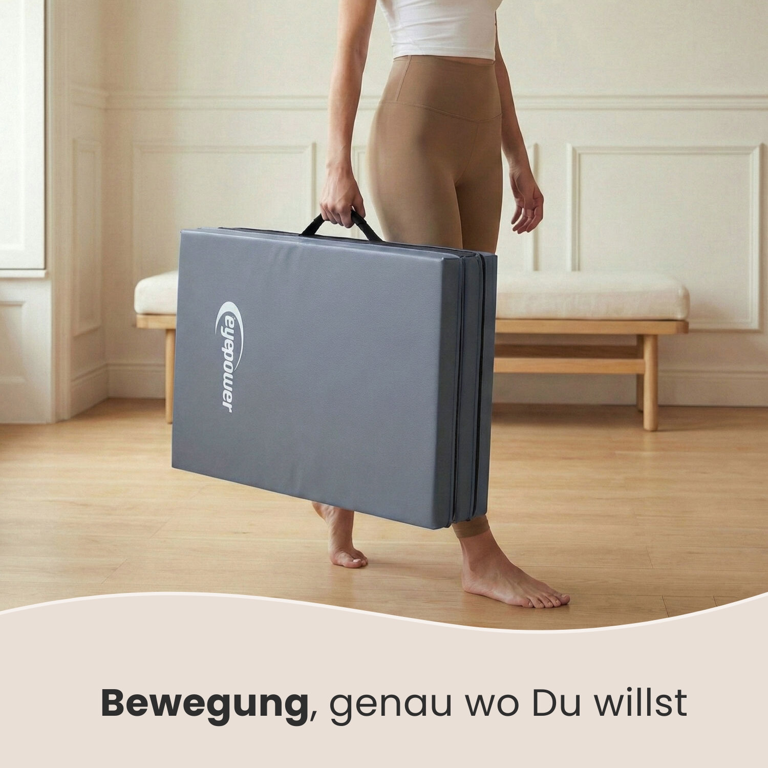 Eine Person trägt eine gefaltete graue Matte mit dem Logo 'eyepower'.