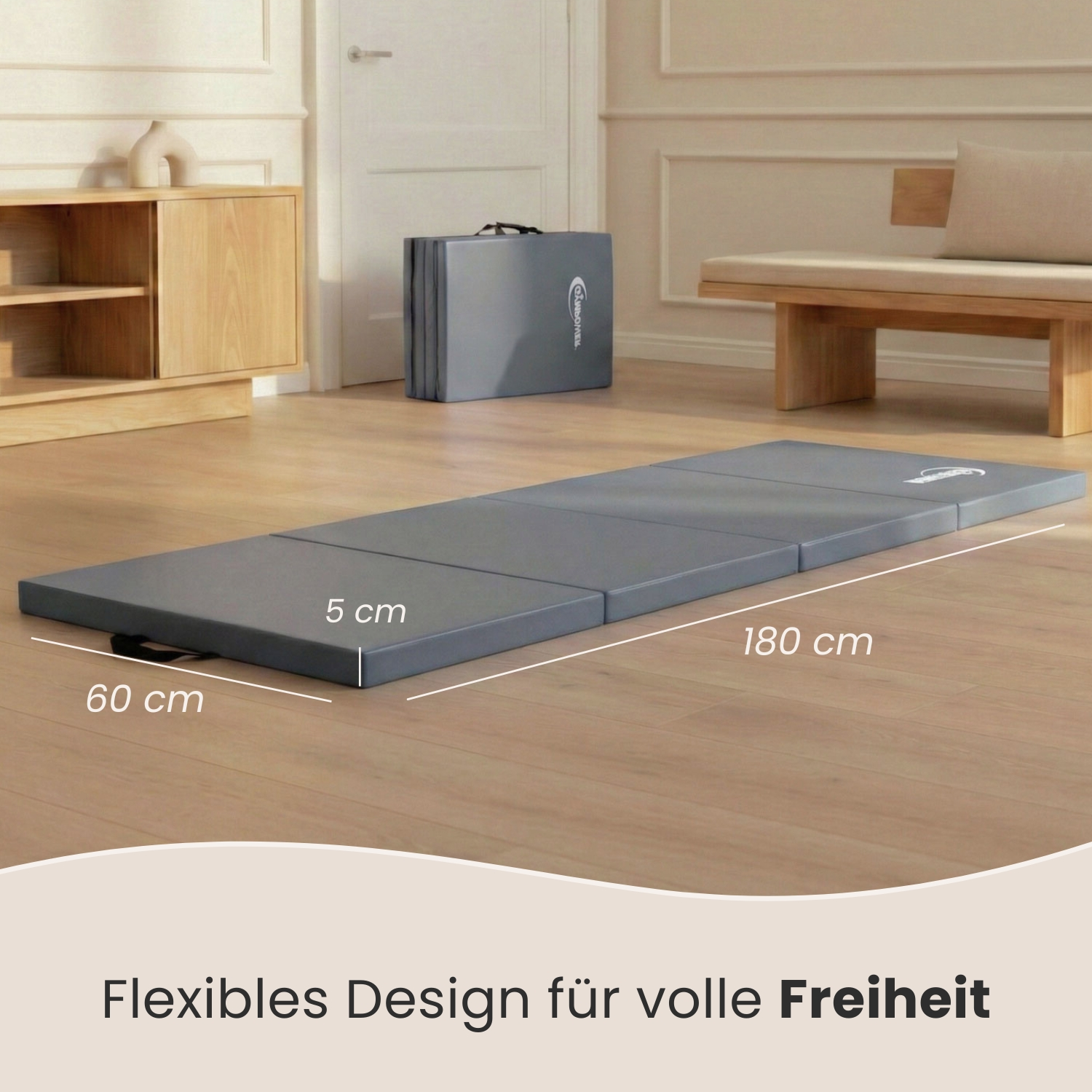Graue Matte, 180x60x5cm, ausgeklappt auf Holzboden, daneben eine Sitzbank und ein Schrank.