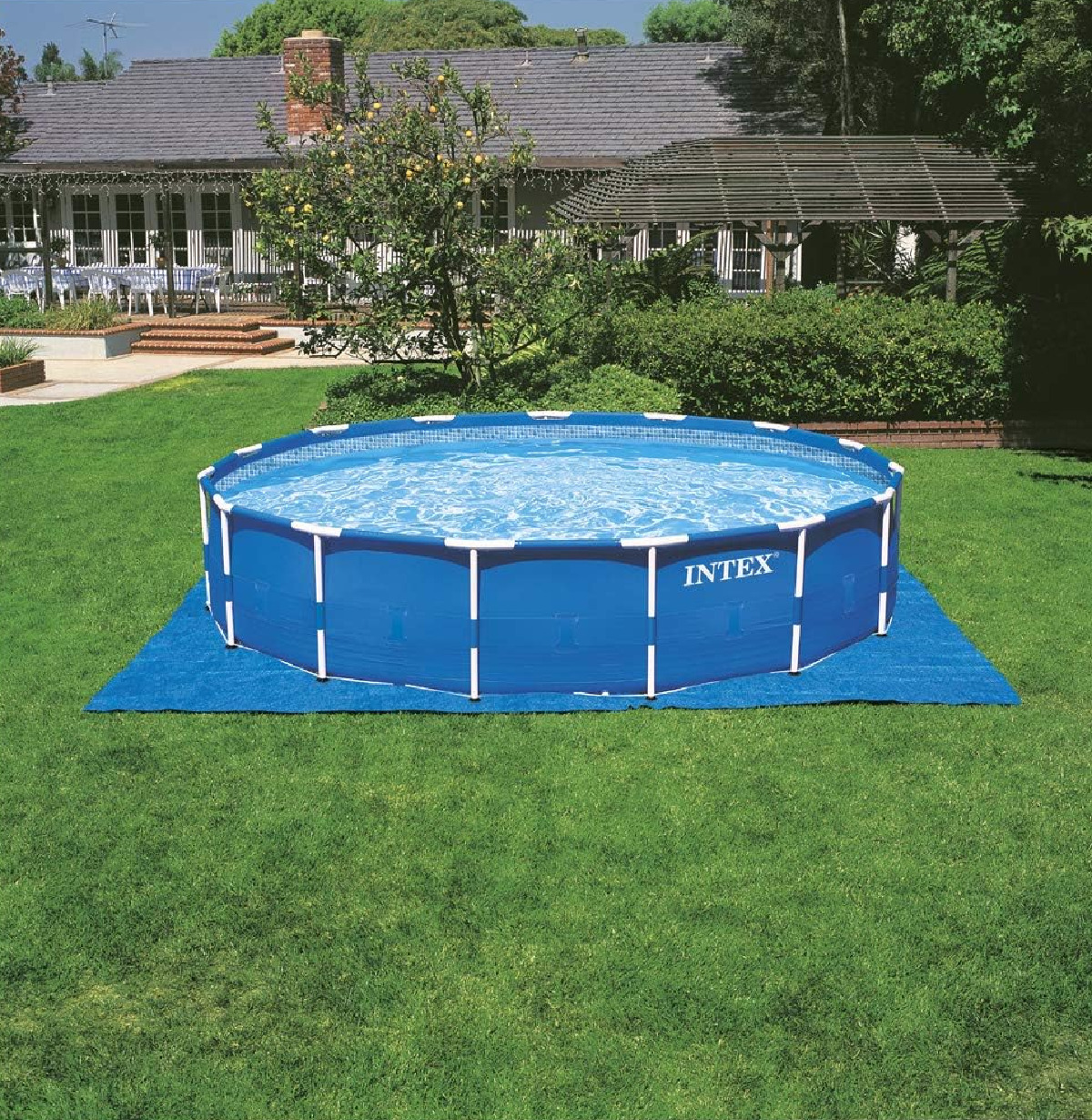 Ein blaues INTEX-Pool steht auf einer blauen Matte im Garten.
