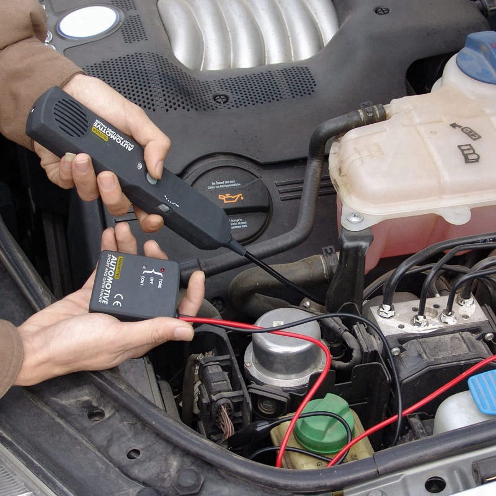 Ein Mann repariert einen Automotor mit einem Werkzeug zur Fehlersuche.