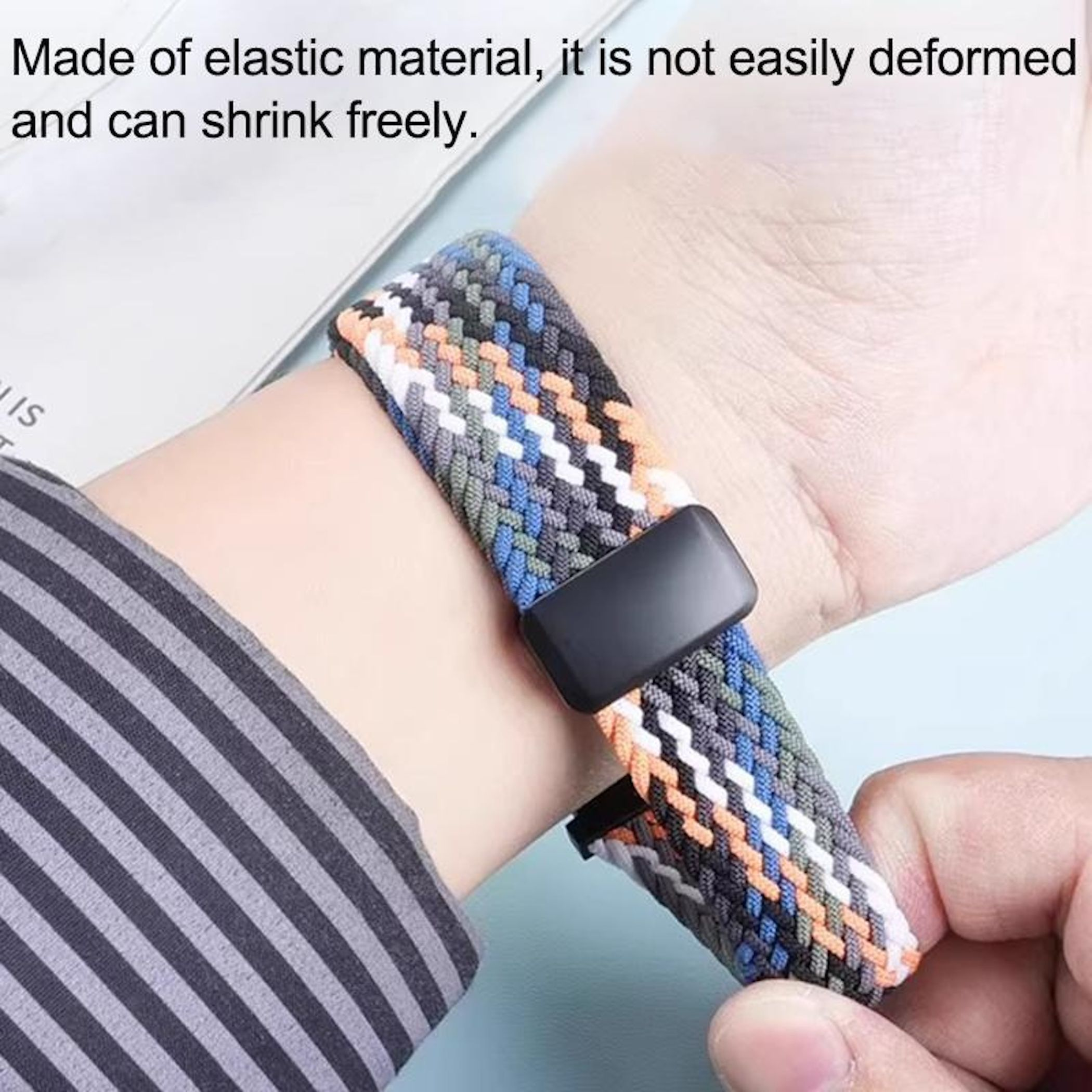 Ein Armband aus elastischem Material mit einem geflochtenen Muster in Grau, Orange und Blau.