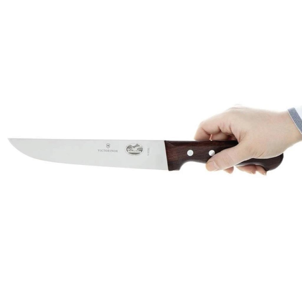 Bir el, ahşap saplı Victorinox bıçağı tutuyor.