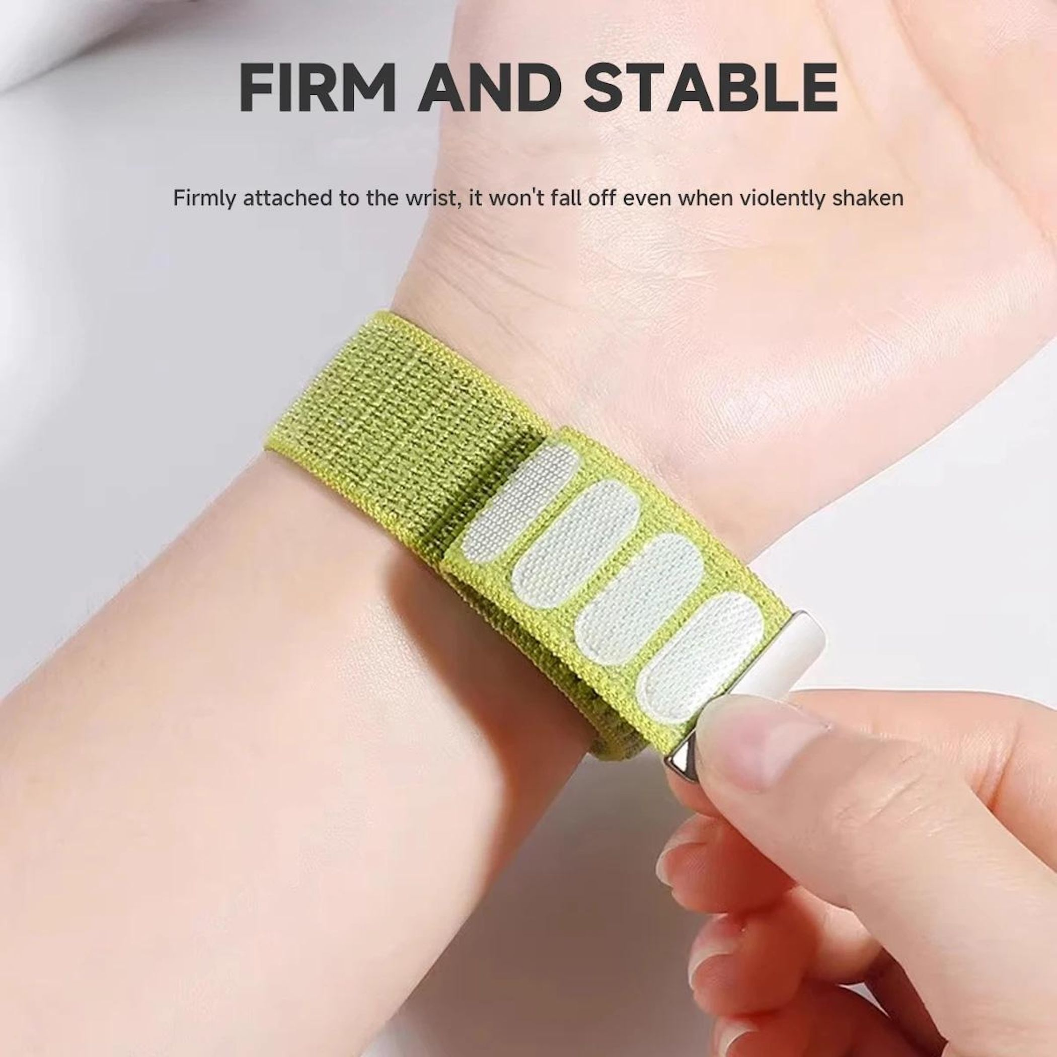 Ein hellgrünes Armband mit Klettverschluss ist an einem Handgelenk befestigt.