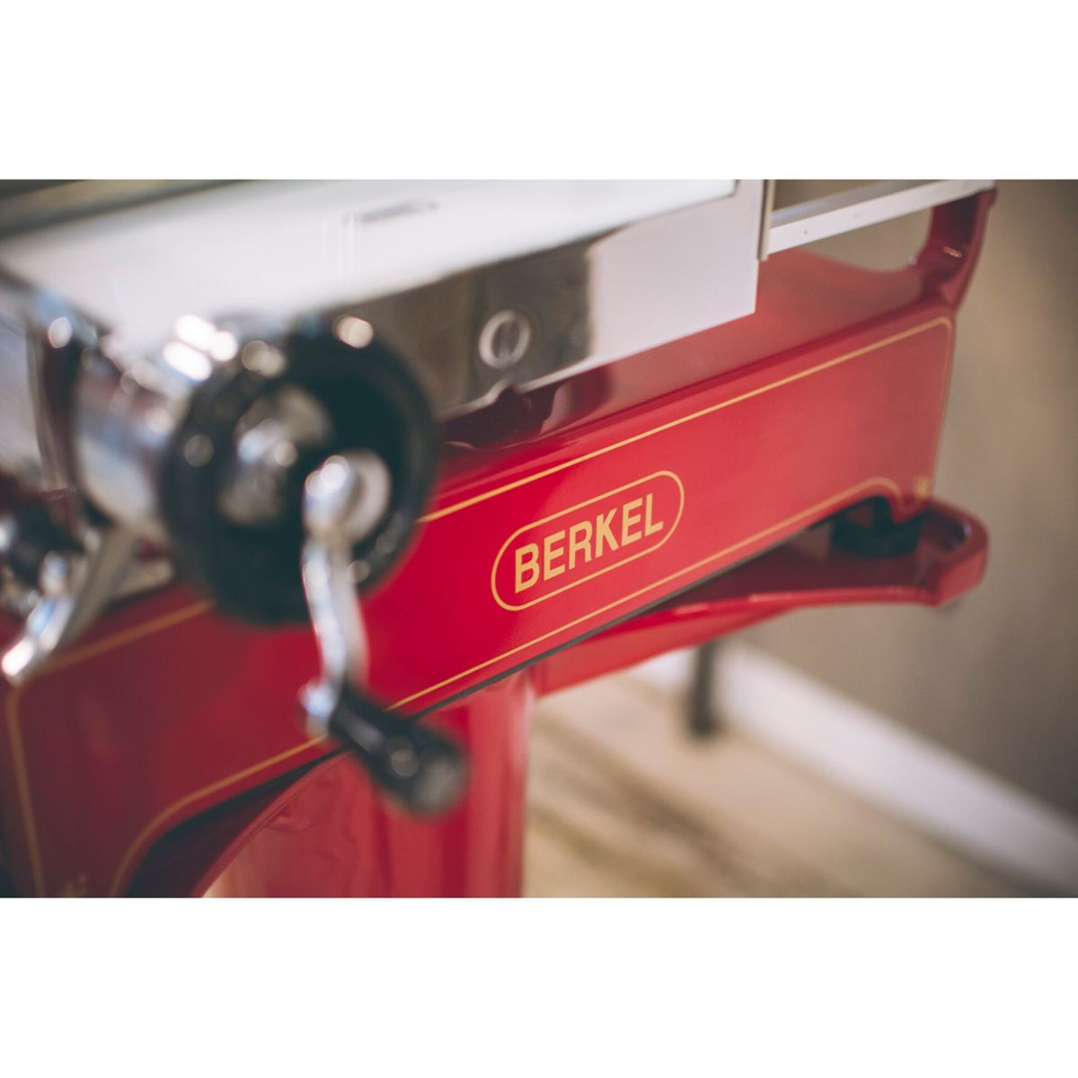 Una affettatrice Berkel rossa con accenti argentati e manico nero.