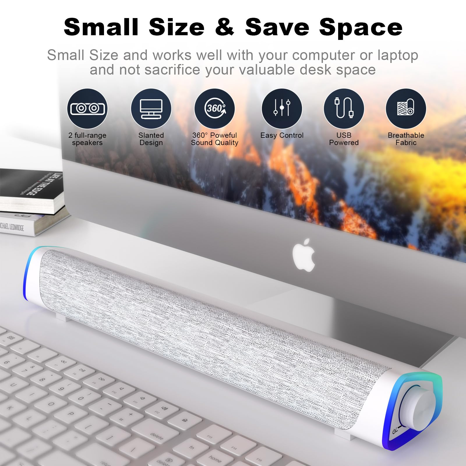 Weiße Soundbar mit Stoffbezug auf einem Schreibtisch neben einer Tastatur und einem Monitor.