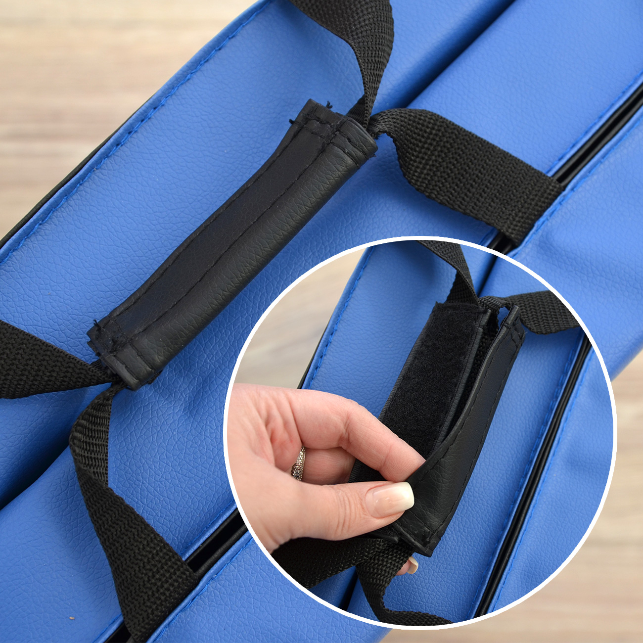 Blaue Tasche mit schwarzem Griff und Klettverschluss. Detailansicht einer Hand.