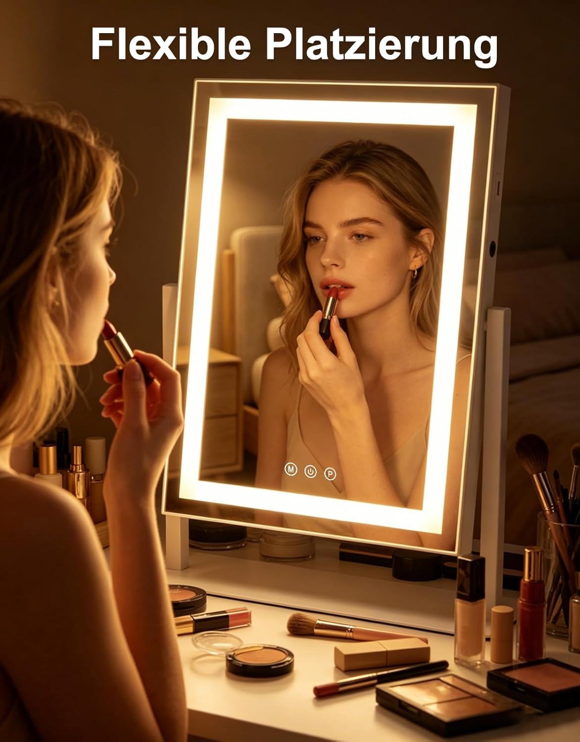 Una donna si applica il rossetto davanti a uno specchio illuminato. C'è del trucco sul tavolo.