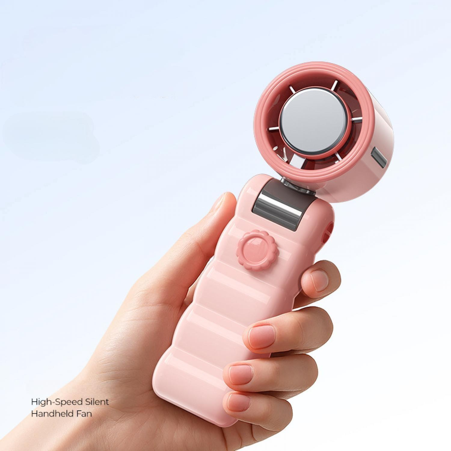 Eine Hand hält einen rosa Ventilator mit silbernen Details vor blauem Himmel.