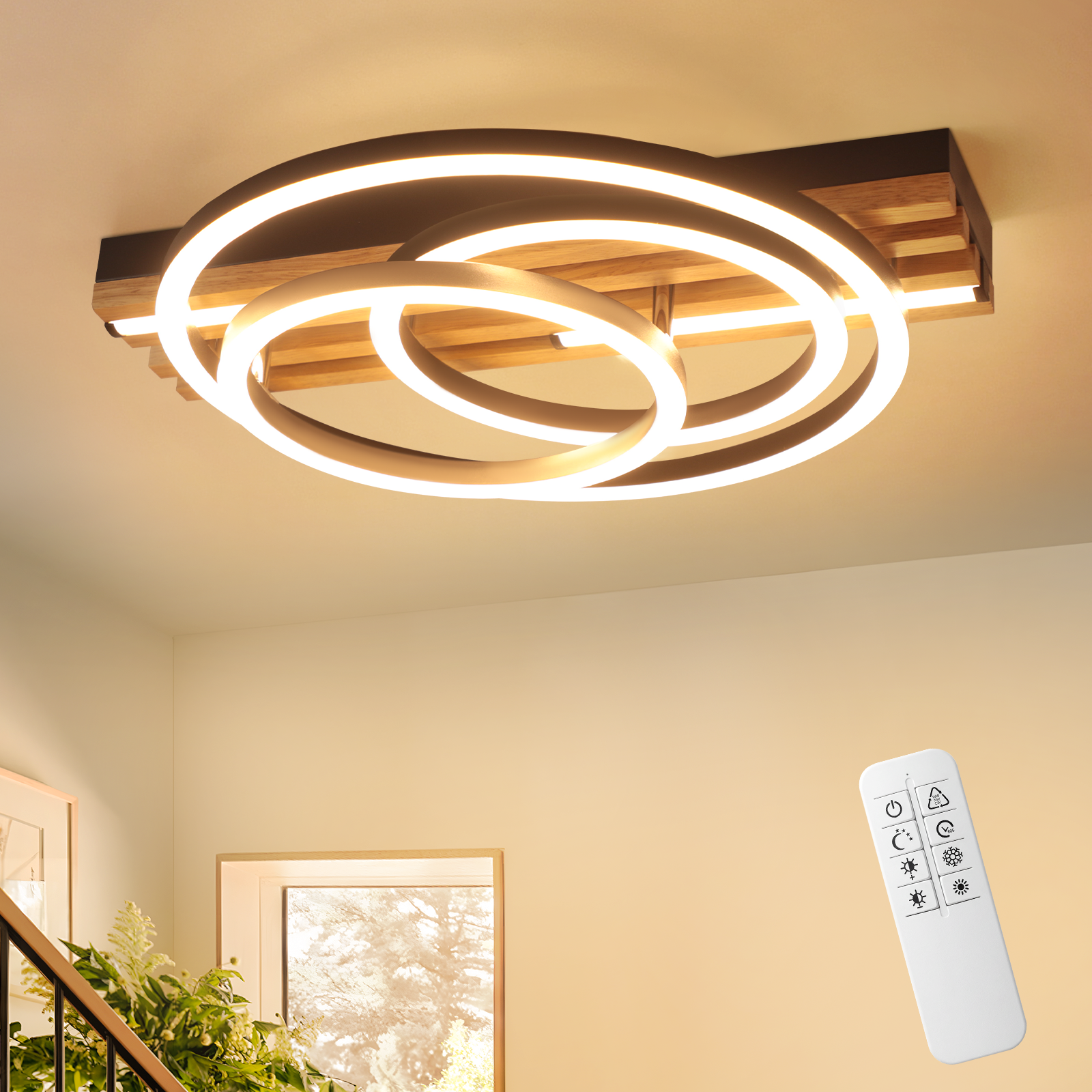 Plafoniera moderna con base in legno e anelli luminosi. Telecomando accanto.
