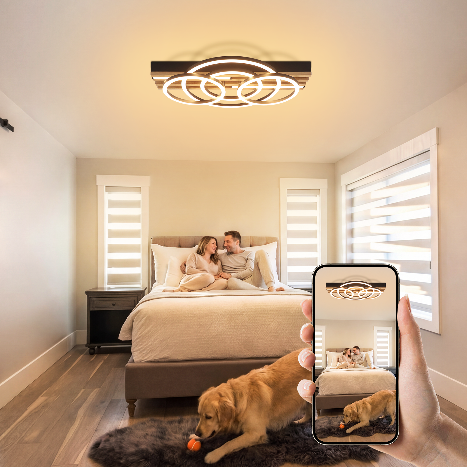 Una coppia seduta su un letto, un cane gioca su un tappeto. Uno smartphone mostra la scena.