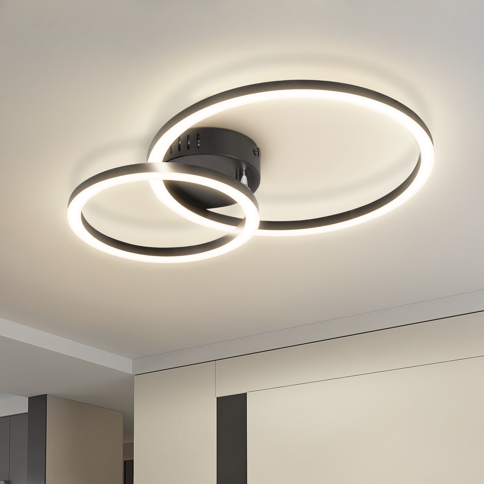 Lampada da soffitto con due anelli sovrapposti che emettono luce calda.