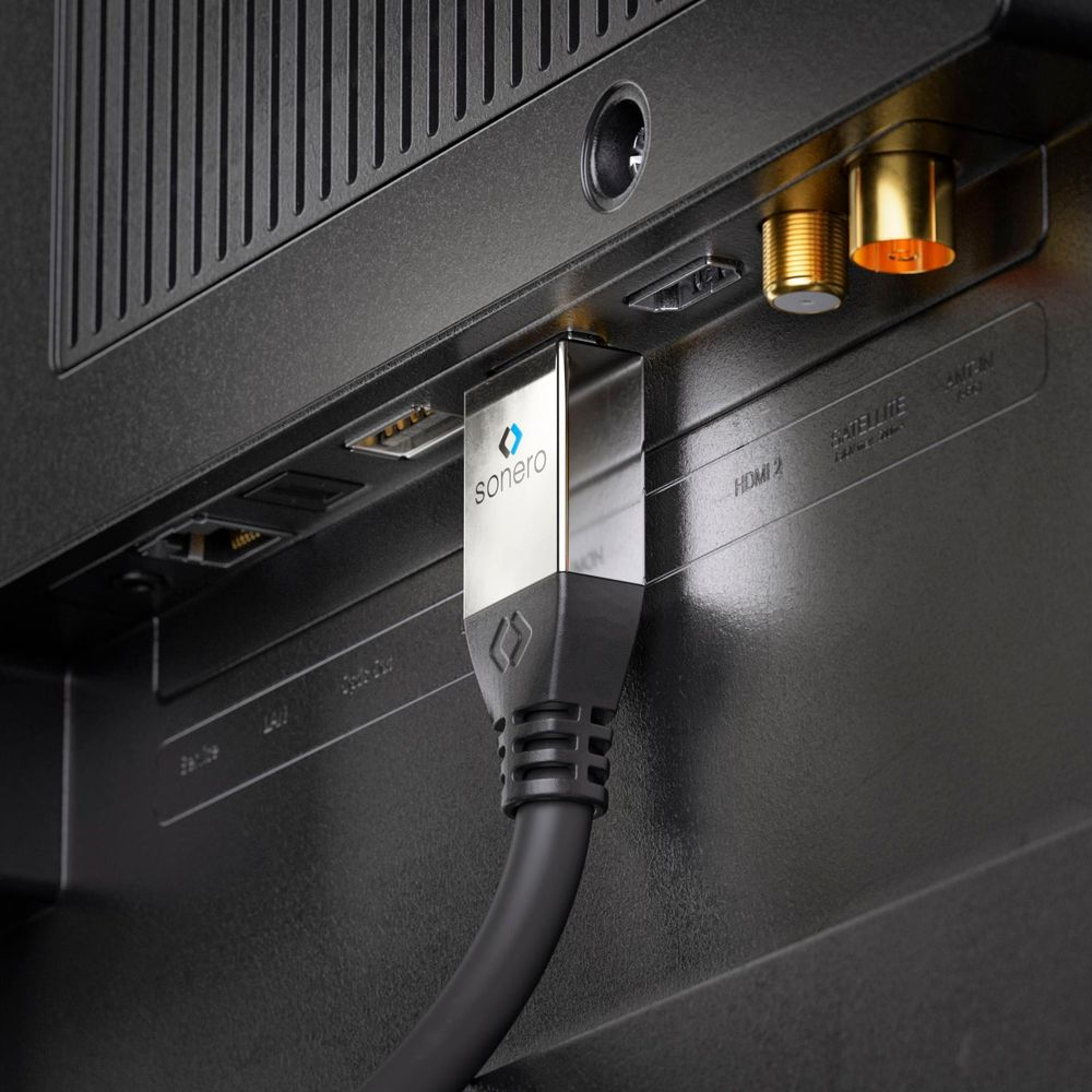 Ein HDMI-Kabel mit silbernem Stecker ist in einen Fernseher eingesteckt.