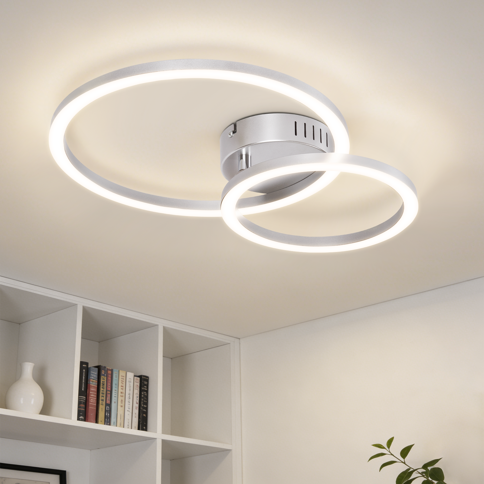Una plafoniera bianca con due anelli intrecciati illumina la stanza.