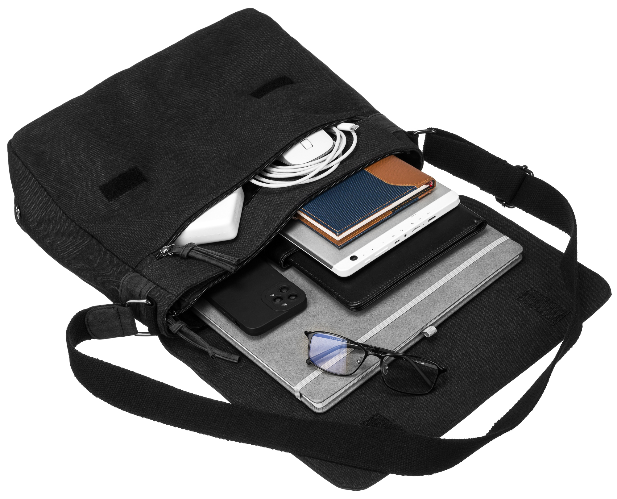 Czarna torba zawierająca laptopa, telefon, notatnik, okulary i ładowarkę.