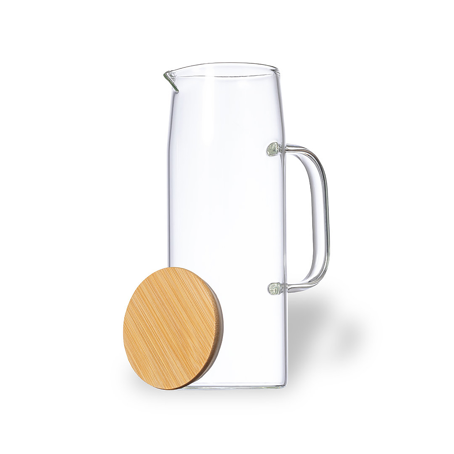 Una caraffa di vetro trasparente con manico e un coperchio rotondo in legno accanto.