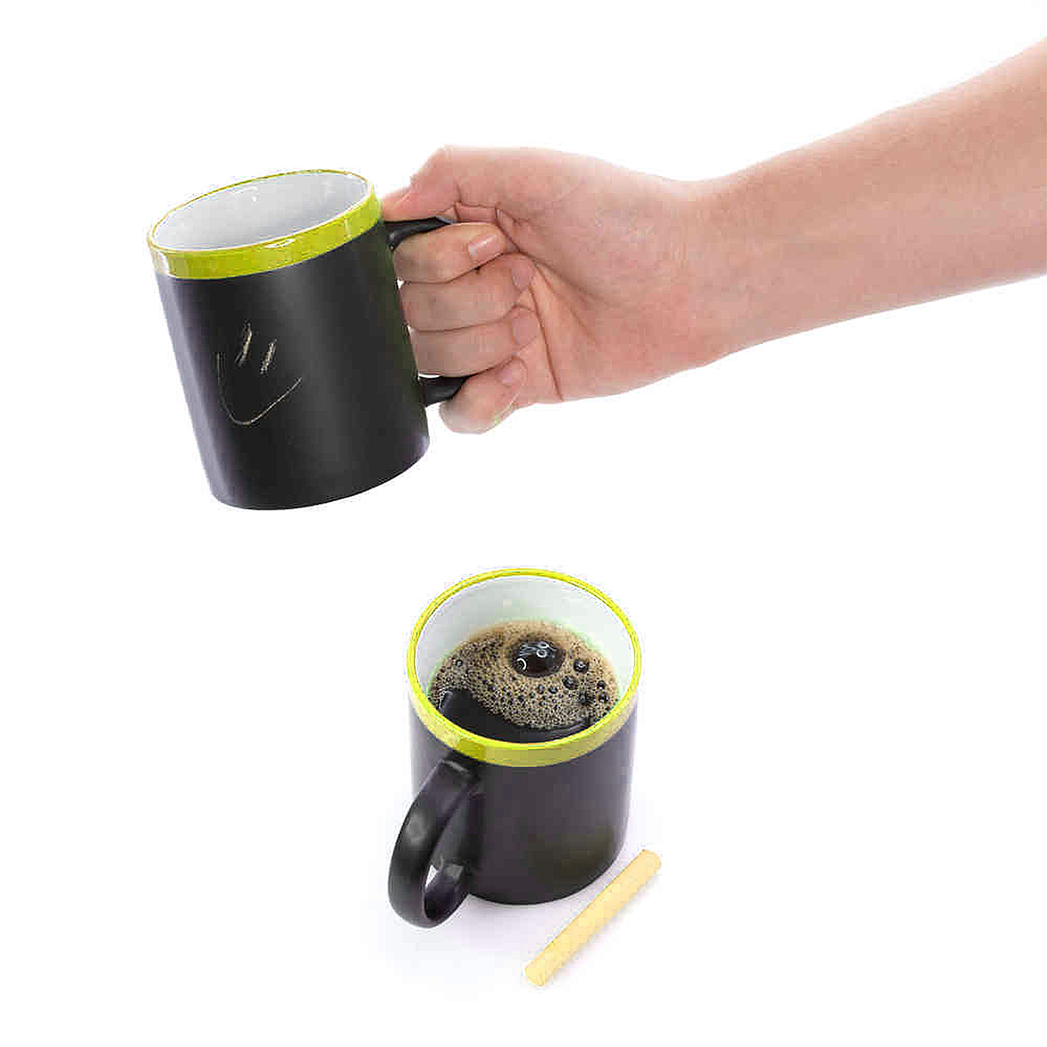 Una mano tiene una tazza nera con una faccina sorridente. Un'altra tazza di caffè è vicina.