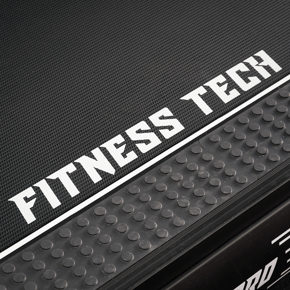 Tapis roulant nero con logo bianco FITNESS TECH e impugnature laterali gommata.