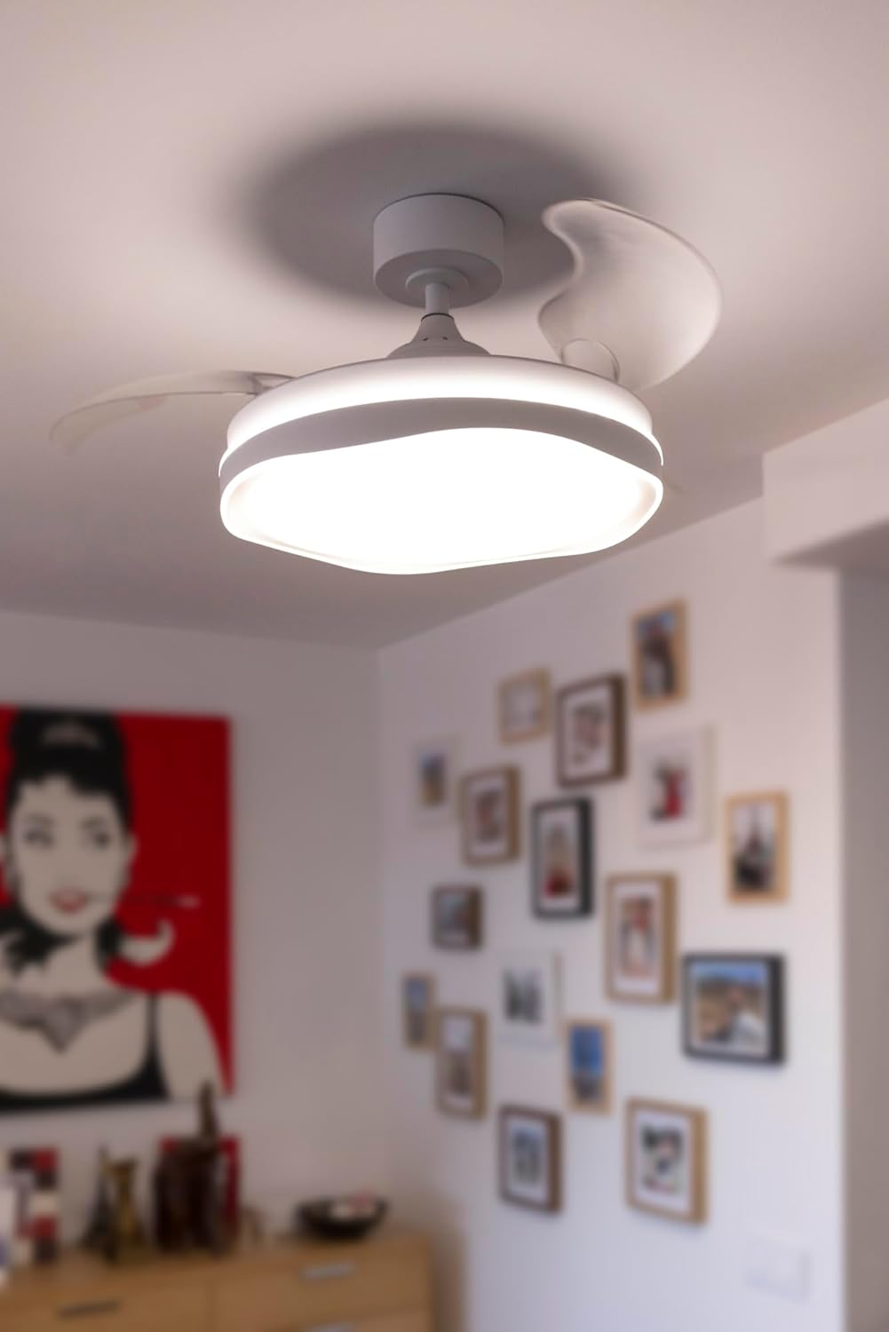 Una lámpara de ventilador de techo blanca con tres aspas está montada en el techo.