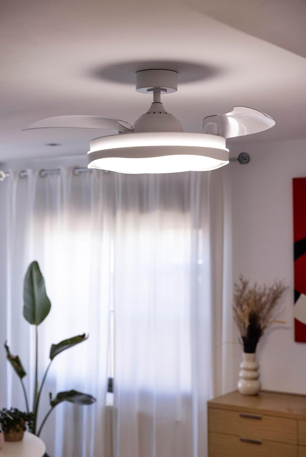 Un ventilador de techo blanco con luz cuelga del techo.