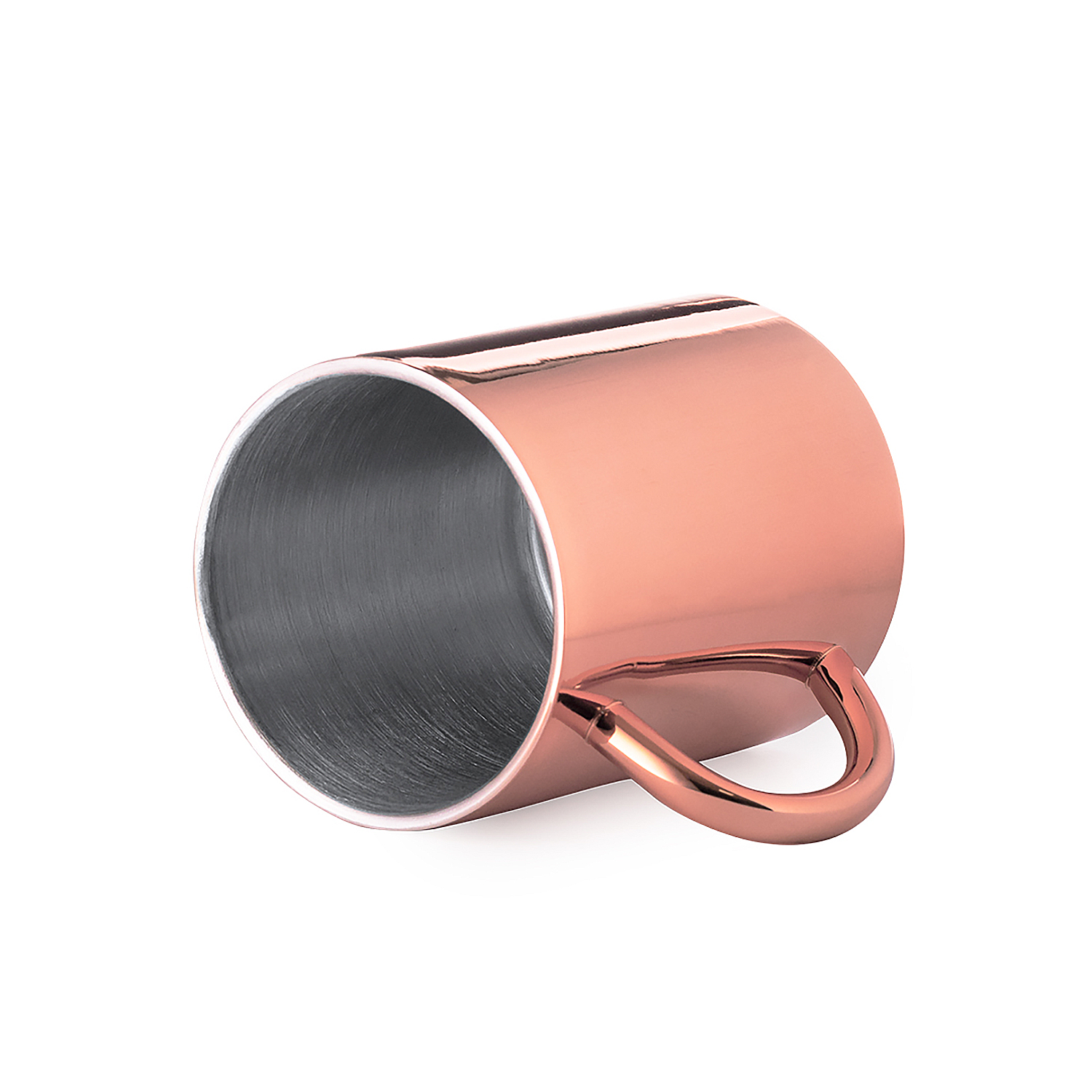 Una taza de cobre brillante con asa yace de lado.