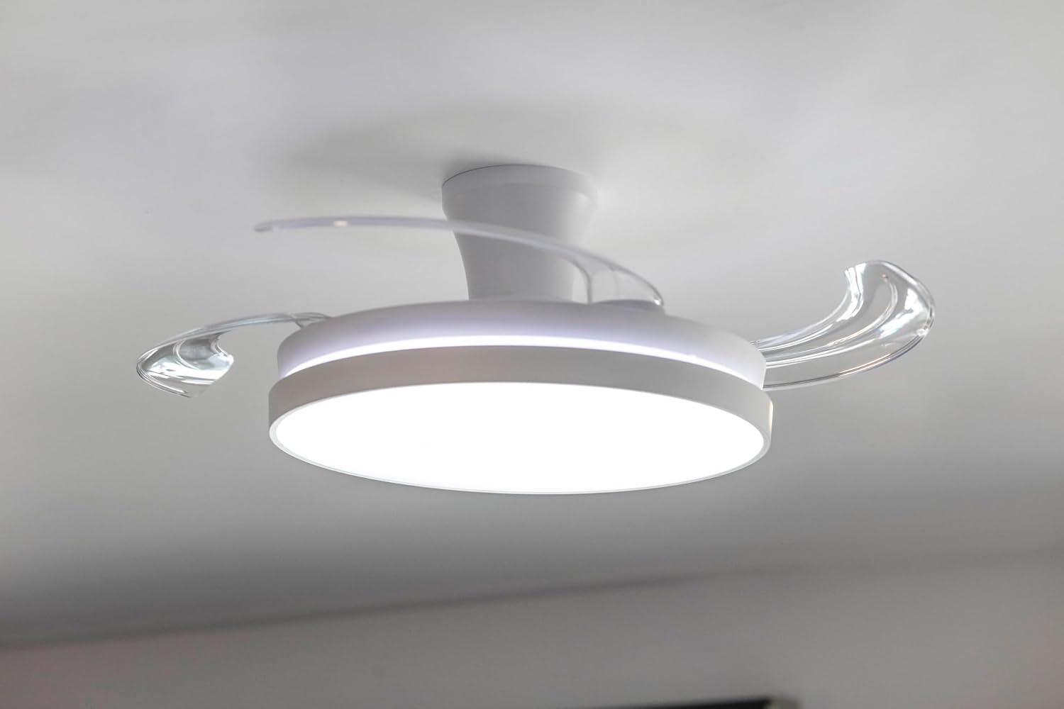 Un ventilador de techo blanco moderno con luz integrada.