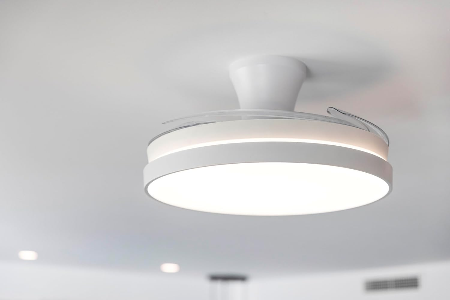 Un ventilador de techo moderno blanco con iluminación integrada.