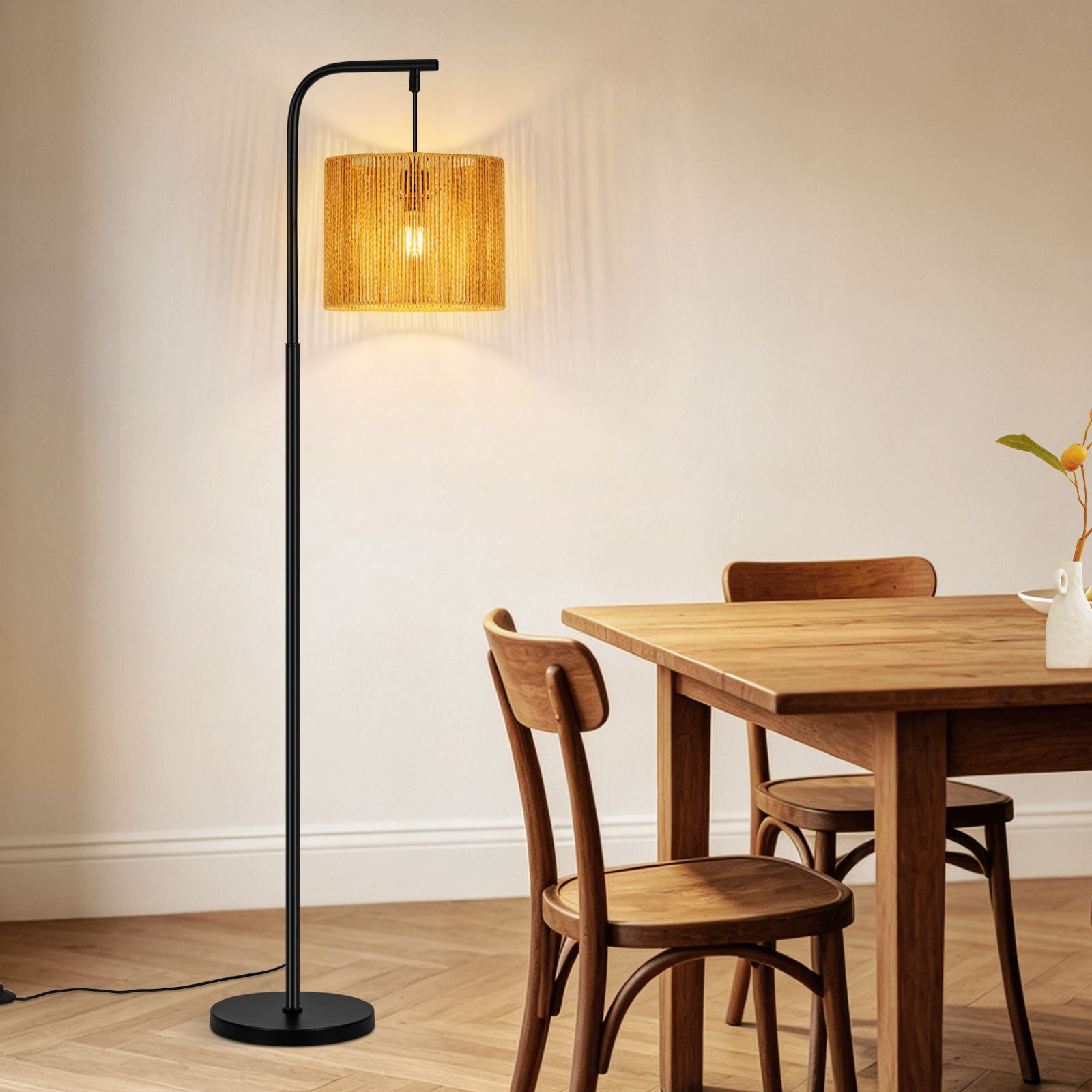 Un moderno lampada da terra nero con paralume intrecciato accanto a un tavolo da pranzo in legno.