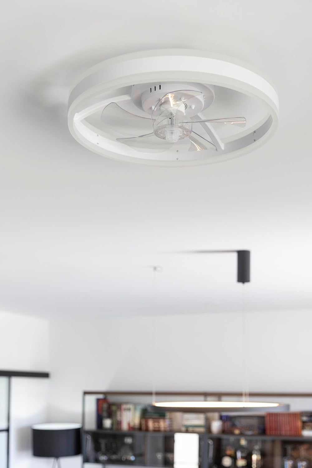 Una luz de techo blanca con ventilador integrado, aspas transparentes e iluminación.