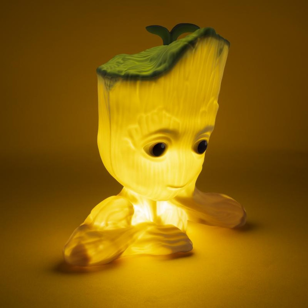 Świecąca lampka Baby Groot oświetlona żółtym światłem na żółtym tle.