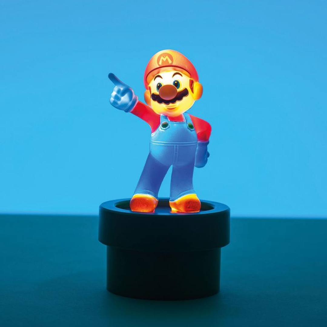Mario-Figur leuchtet und steht auf einem schwarzen Rohr vor blauem Hintergrund.
