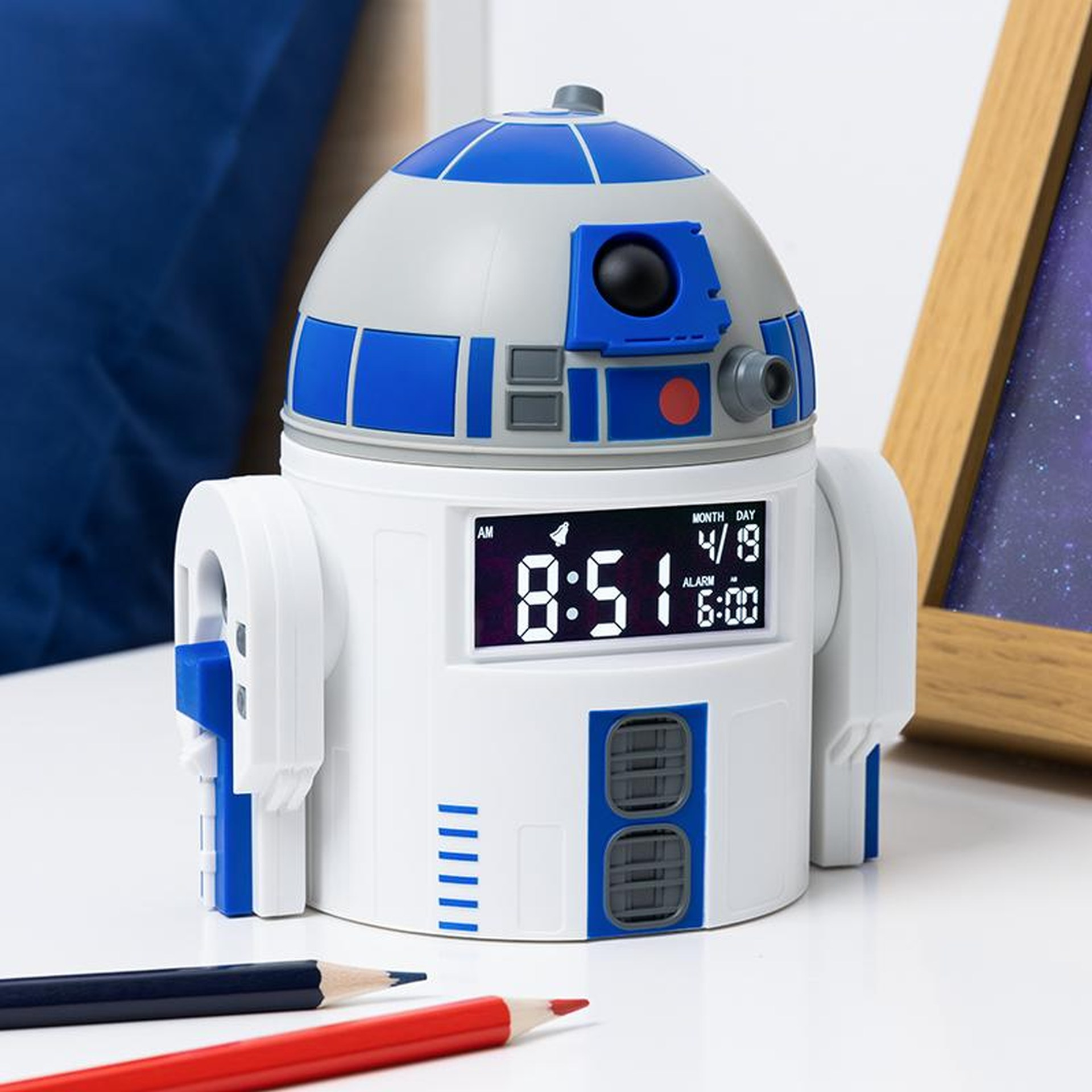Biały budzik R2-D2 z cyfrowym wyświetlaczem na białym stole.