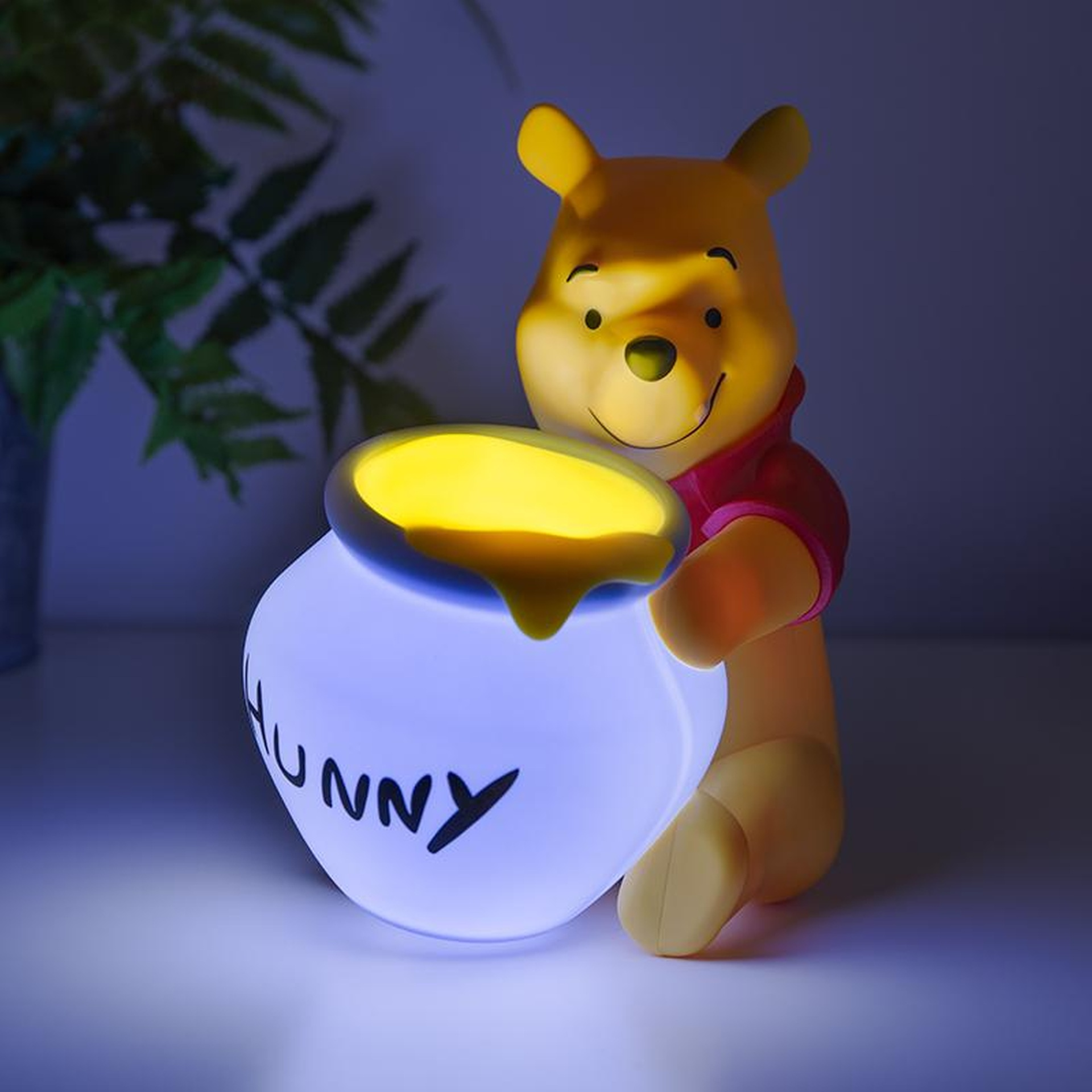 Kubusiowi Puchatkowi trzymającemu świecący nocny.