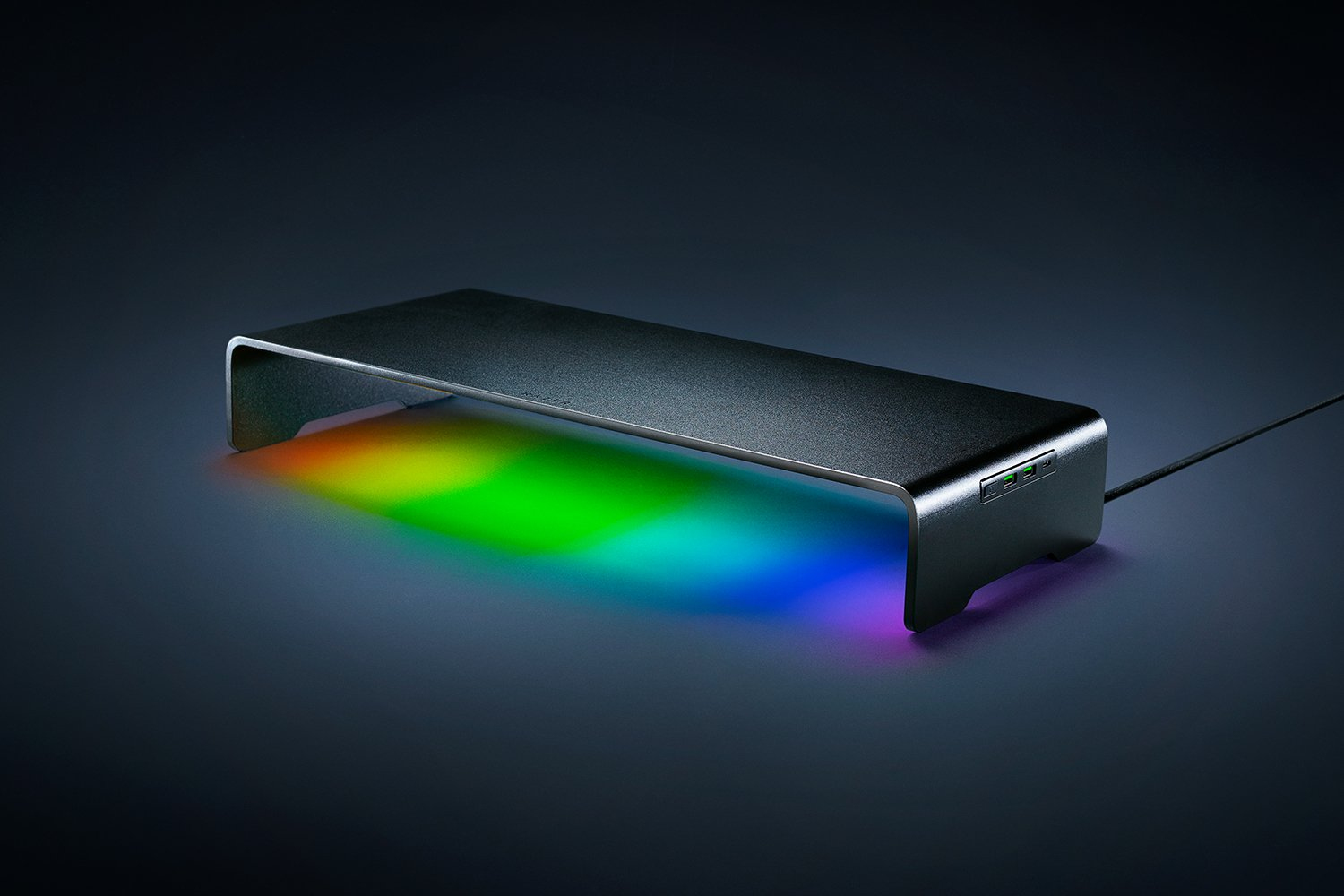 Schwarzer Monitorständer mit RGB-Beleuchtung auf dunklem Hintergrund.
