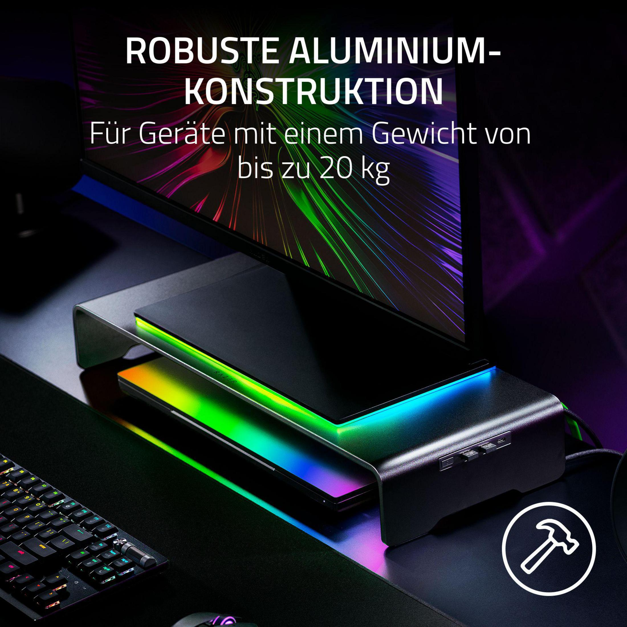 Ein Monitorständer aus Aluminium mit RGB-Beleuchtung steht auf einem Schreibtisch.