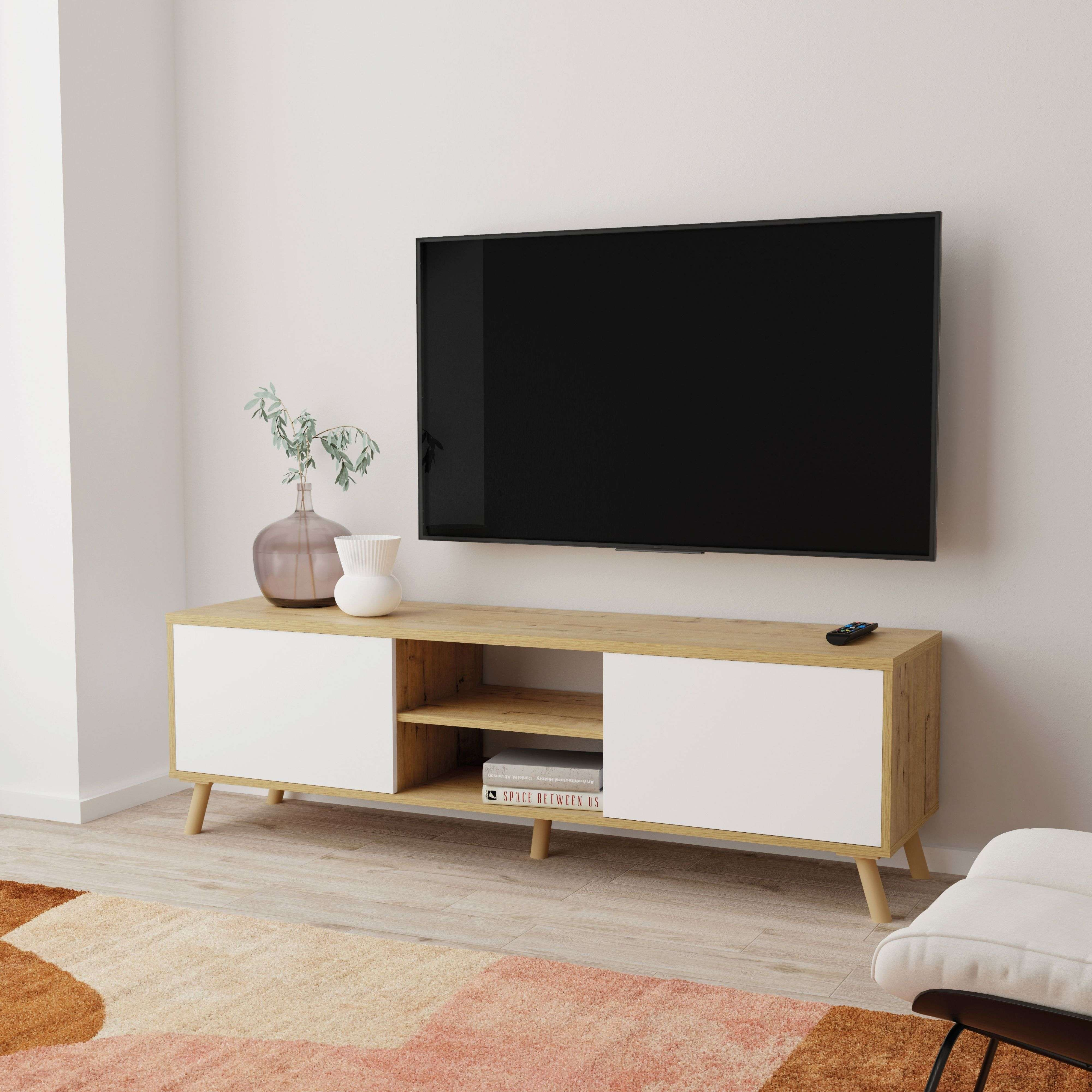 Un mueble de TV moderno con puertas blancas, tapa de madera y televisión montada.