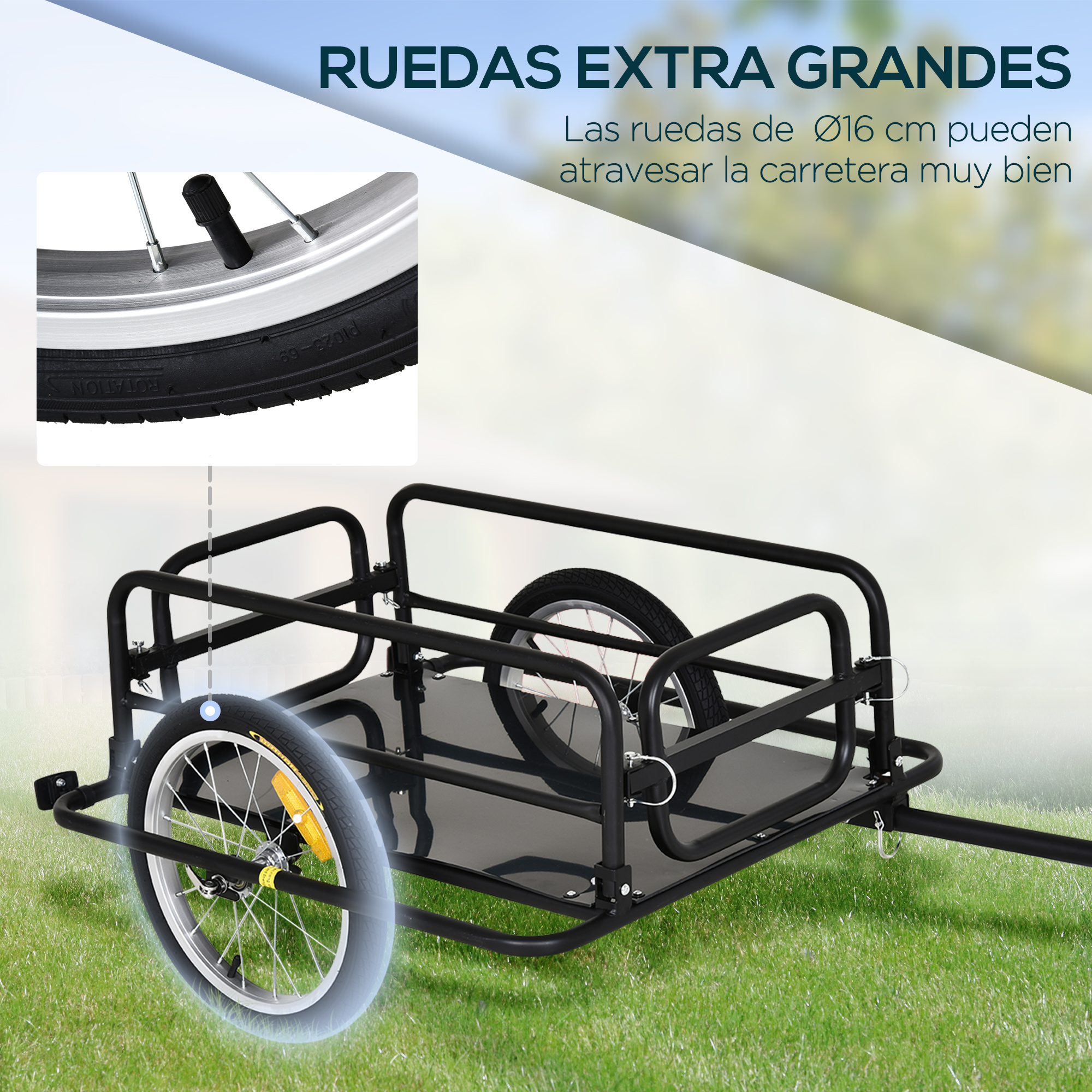 Remolque negro para bicicleta con dos ruedas sobre césped, primer plano de una rueda.